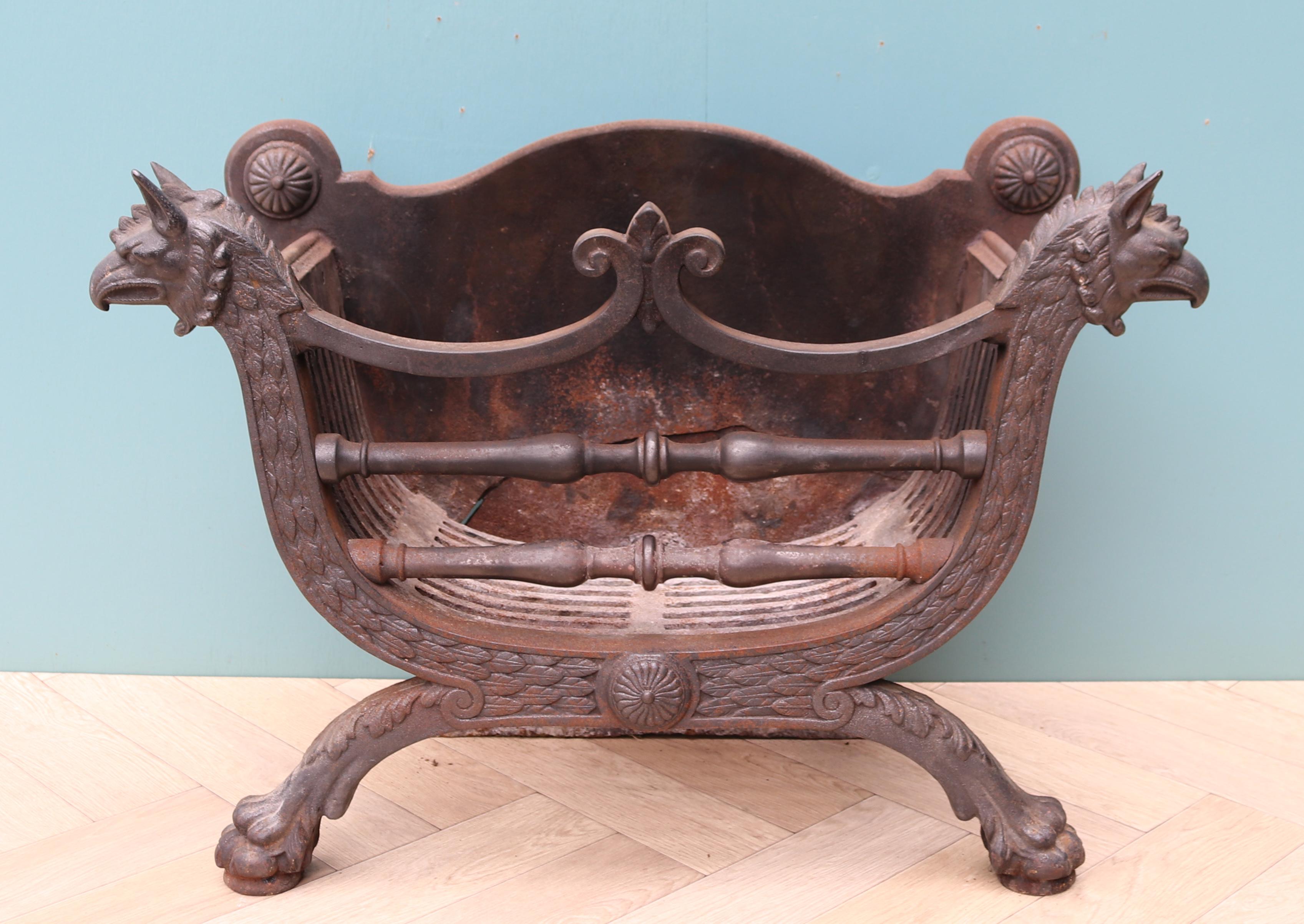 An elegant Regency style cast iron fire basket decorated with griffin heads and feet.