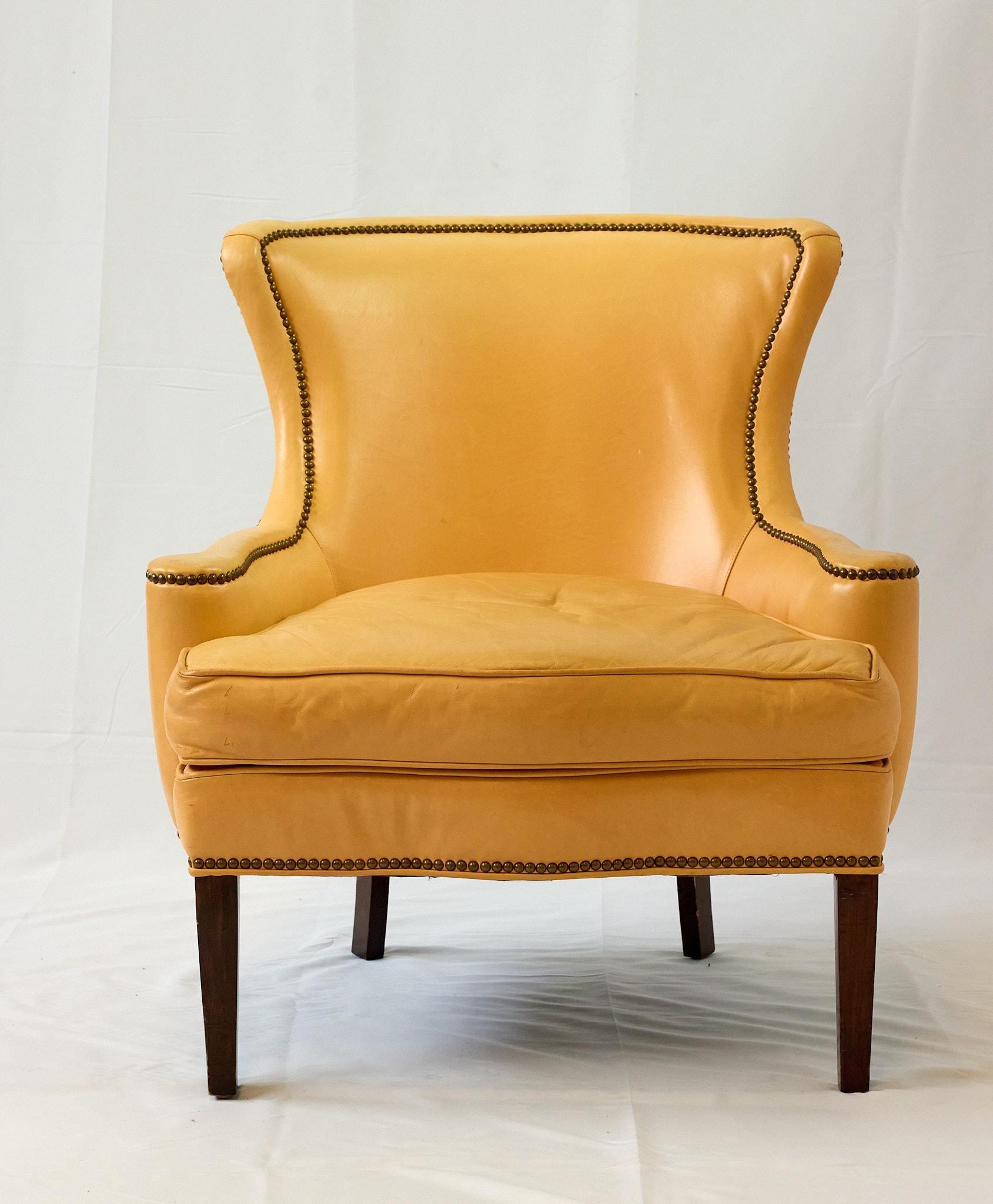 Fauteuil de style Regency de la fin du XXe siècle, en cuir d'une teinte abricot unique, fabriqué par Southwood Reproductions, Hickory, Caroline du Nord. Le dossier en forme de bouclier, les accoudoirs et le tablier de la chaise sont rehaussés de