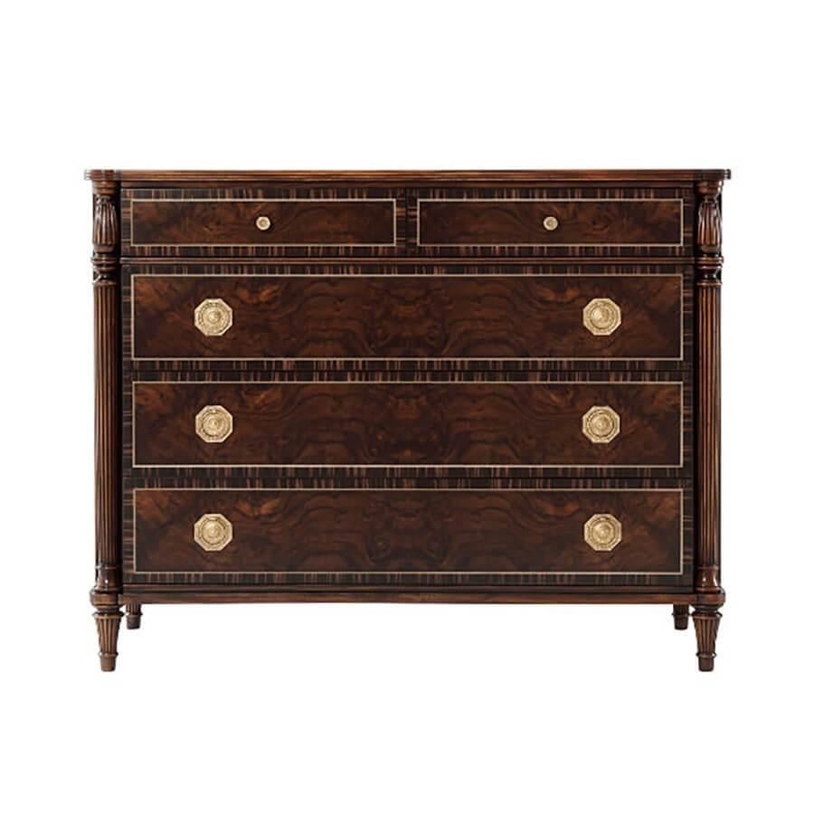 A Regency style Treviso finish walnut burl, and triple line strung chest of drawers with ebonized banding and sides, the re-entrant cornered top above two reeded and turned columns enclosing two short and three long drawers with fine brass handles,