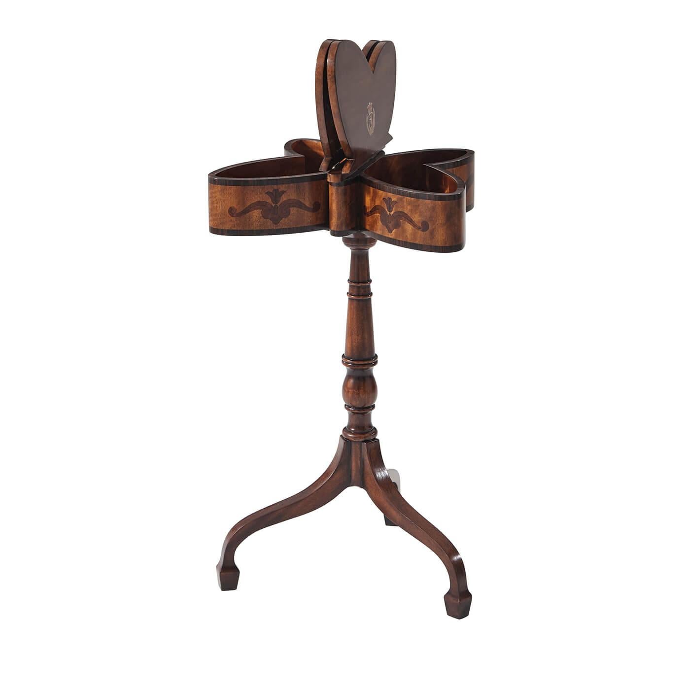 An English Regency style marquetry inlaid butterfly work table, the top inlaid with rosewood, burl and amboyna and with two hinged wing panels opening to reveal the painted Spencer crest, on a ring and baluster turned column and delicate down swept