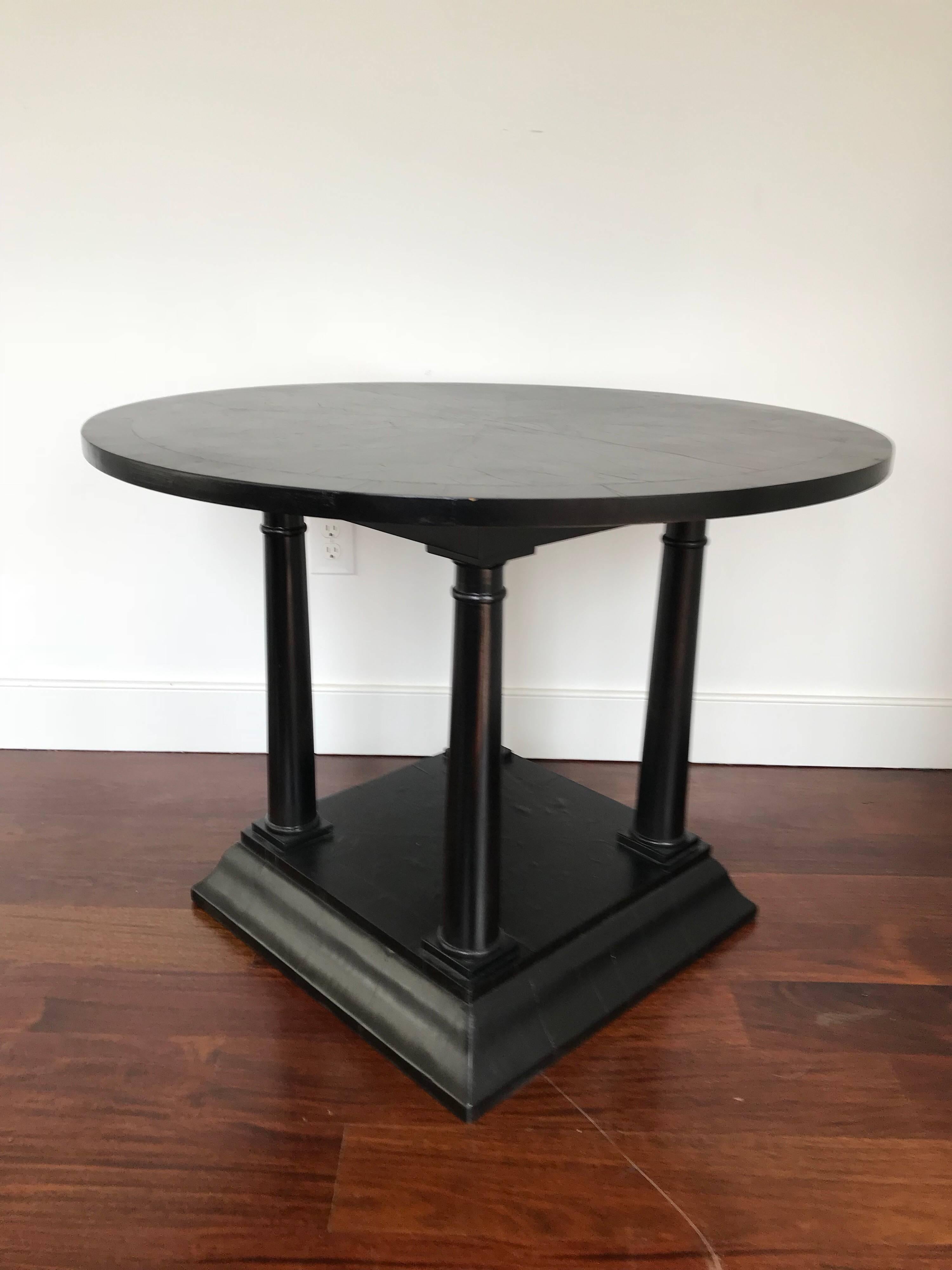 A handsome Regency style centre table with ebonized finish. Lower pediment connected to circular top by four column shaped legs.