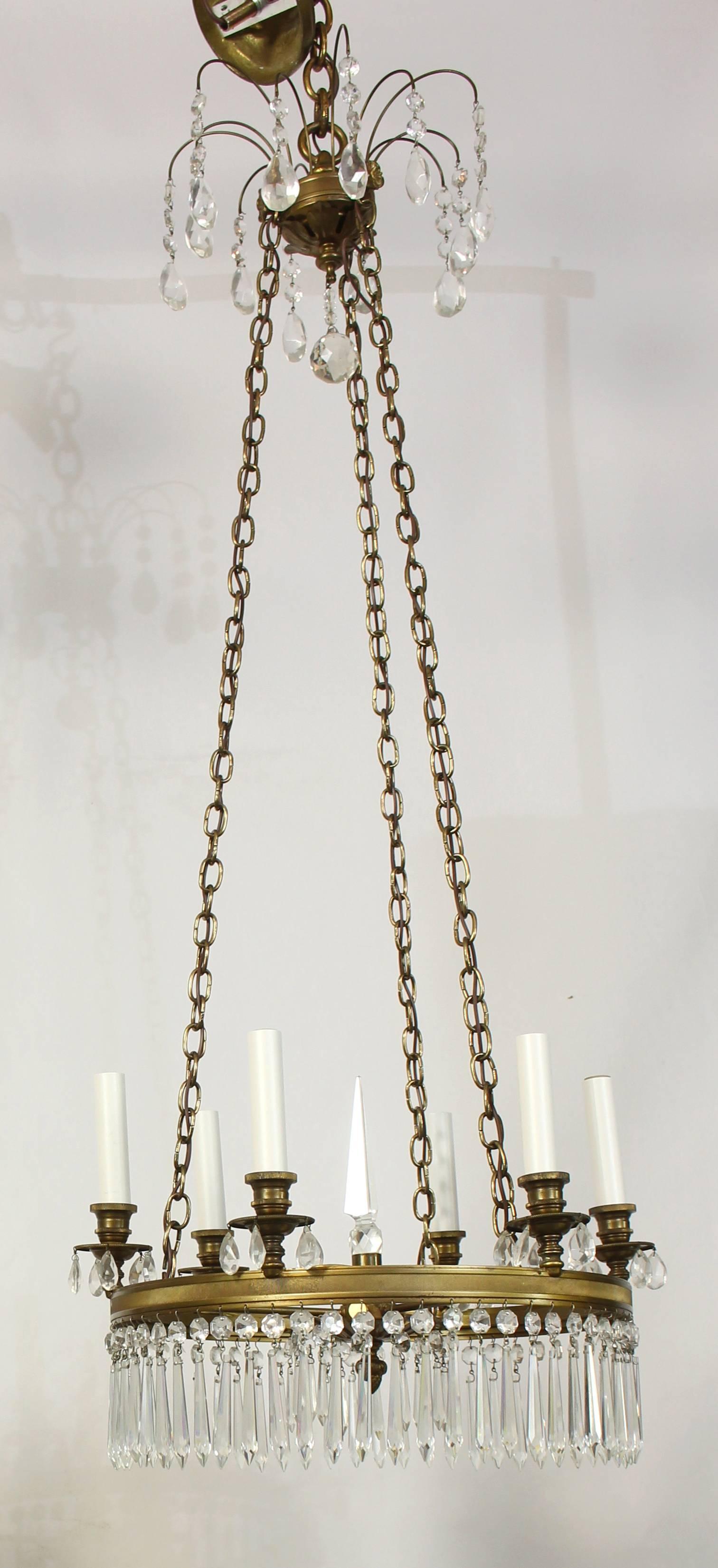 An elegant brass and crystal Regency style six light chandelier dating from the early 1960s. The three chains can be shortened to adjust the overall length of the light.