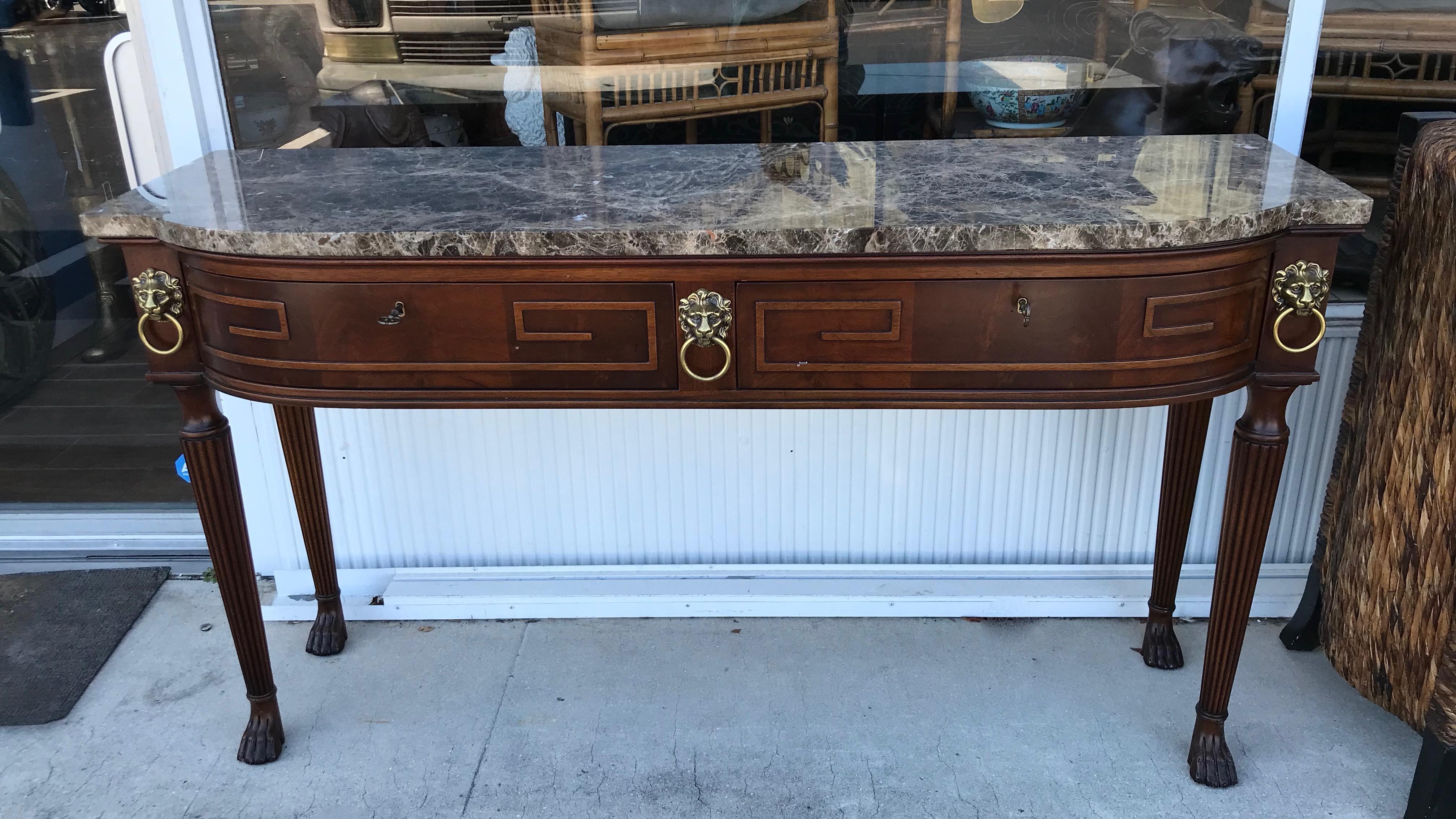 Finely fashioned and decorated with brass lion's head appointments.
The console is topped with beautiful marble and contains 2 drawers
with keys. It terminates with paw feet. Outstanding Henredon quality.