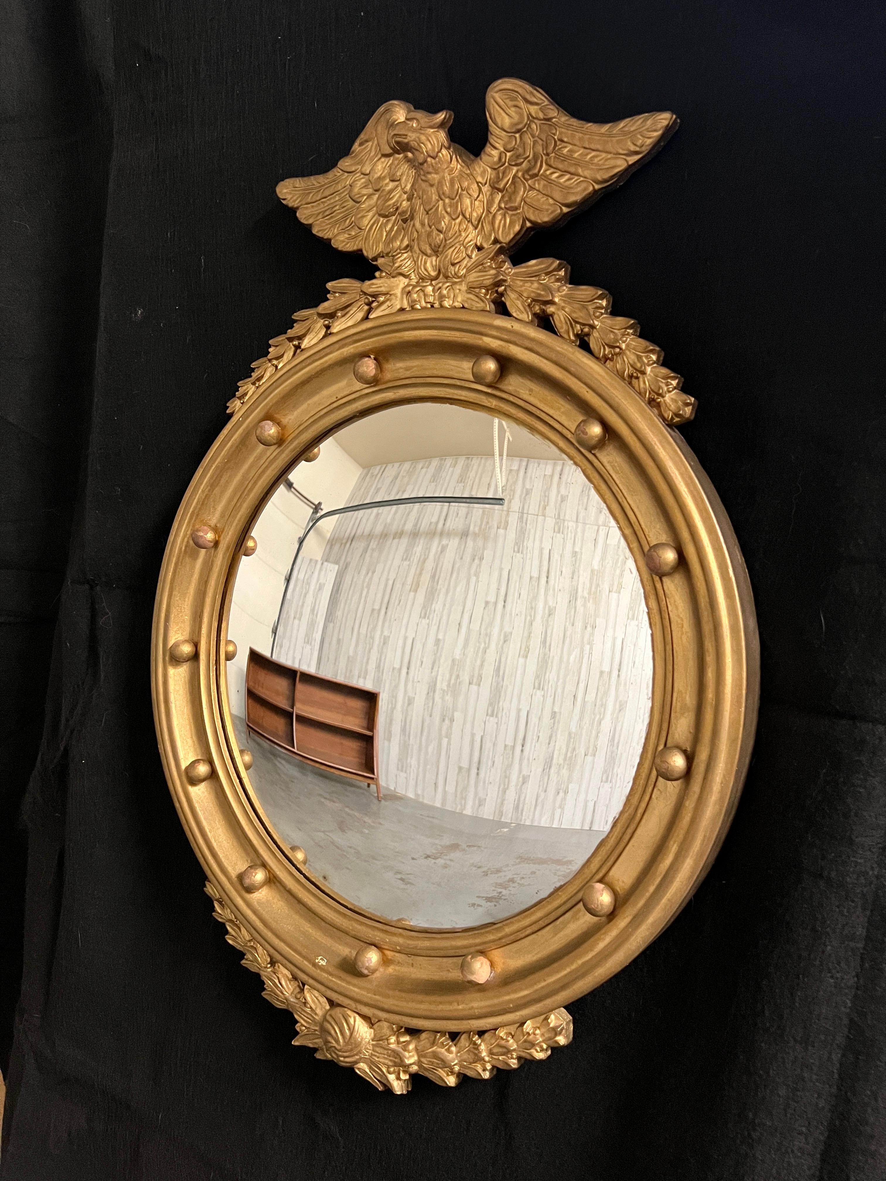 Carved wood with gesso and gold metal finish Regency style convex mirror.
