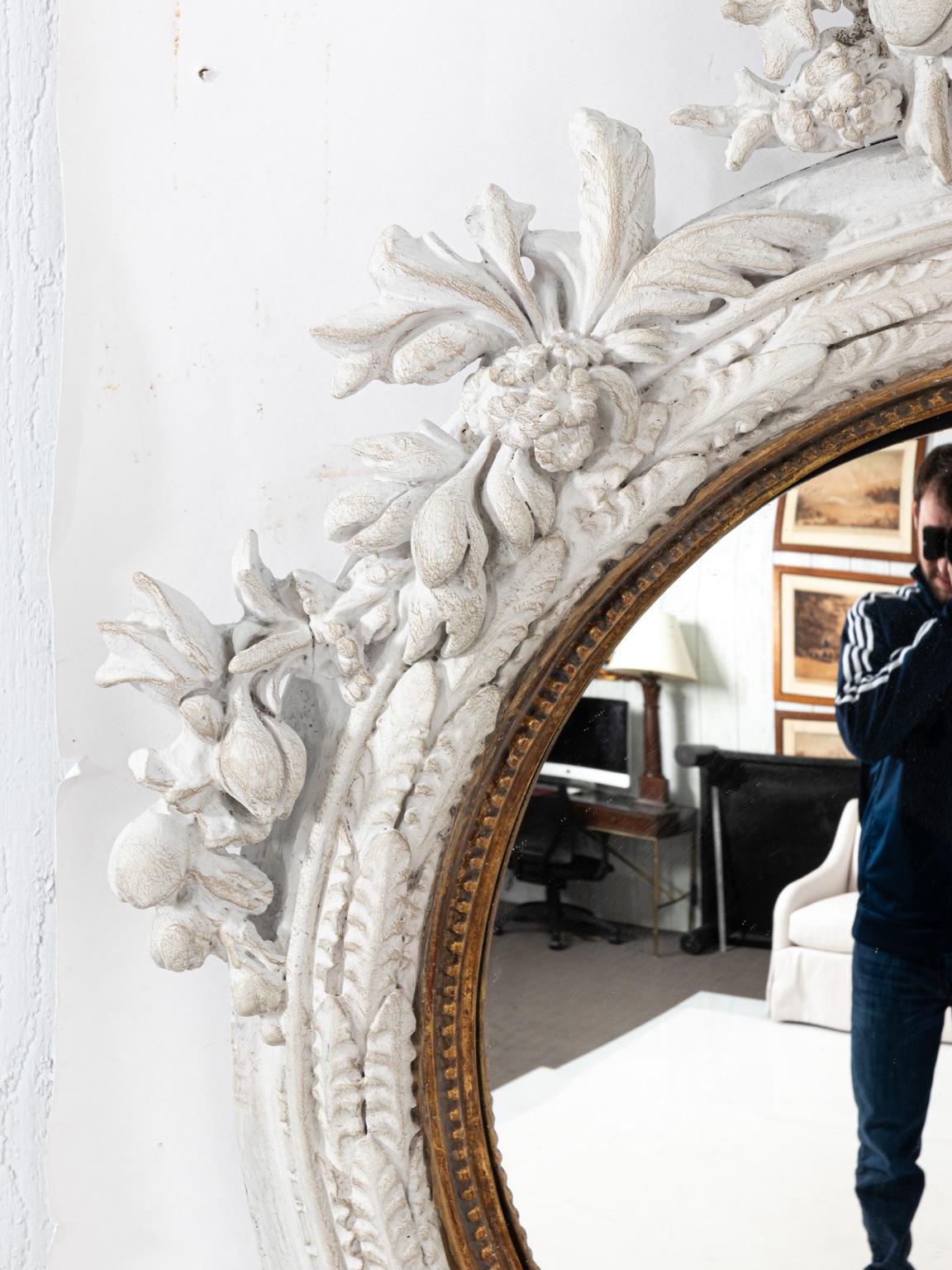 Regency style convex wall mirror with Grisaille plaster basket of flowers on the crest. Please note of wear consistent with age.