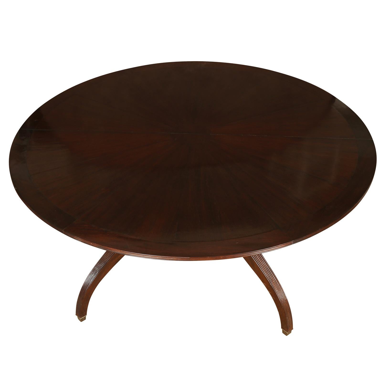 A custom mahogany round dining table with a pedestal base in Regency style. Table can open to 111