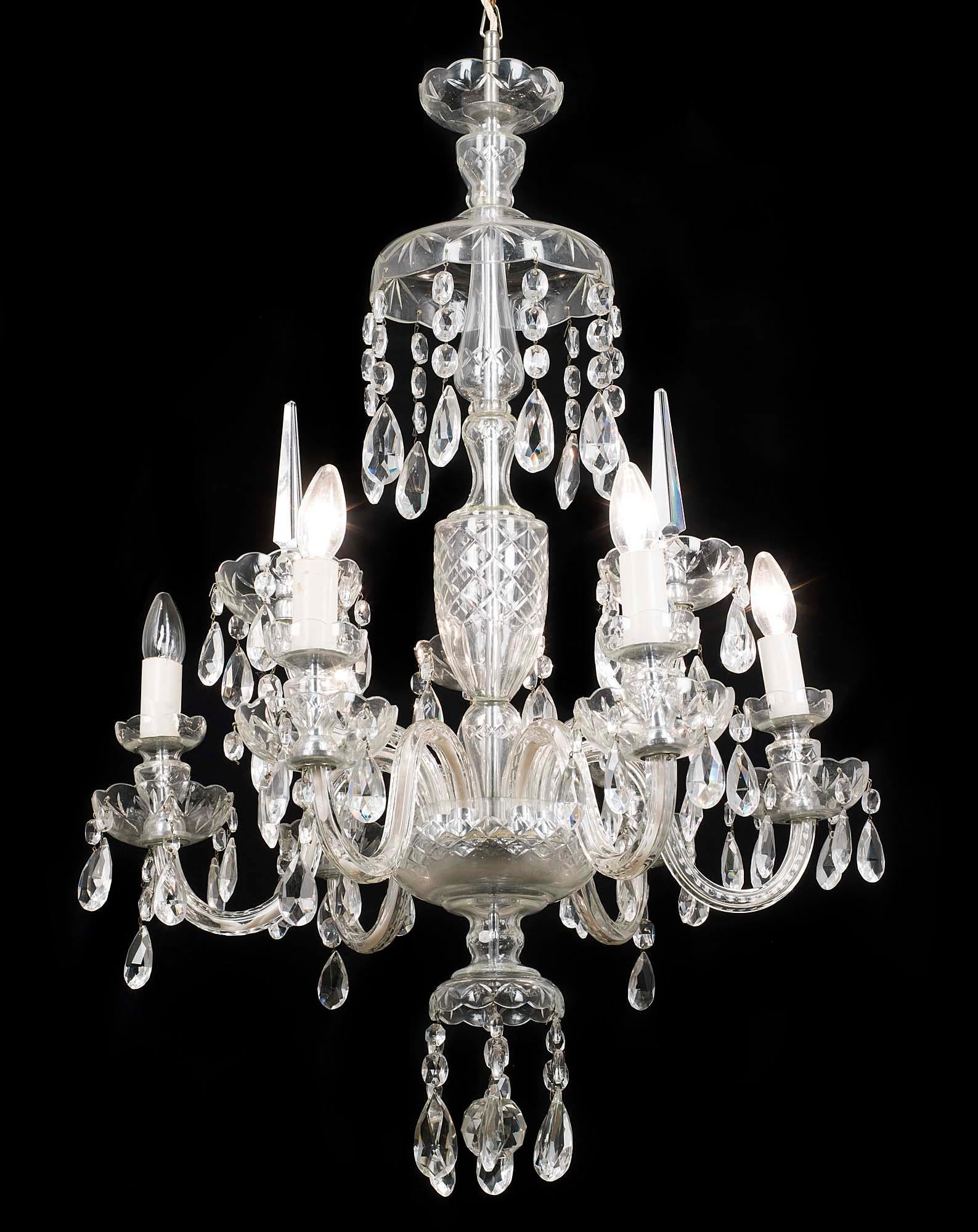 A 20th century Regency style cut-glass nine branch chandelier. The shaped glass stem issuing nine arms over two graduated tiers and hung with cut-glass drops.
English, mid-20th century.
 