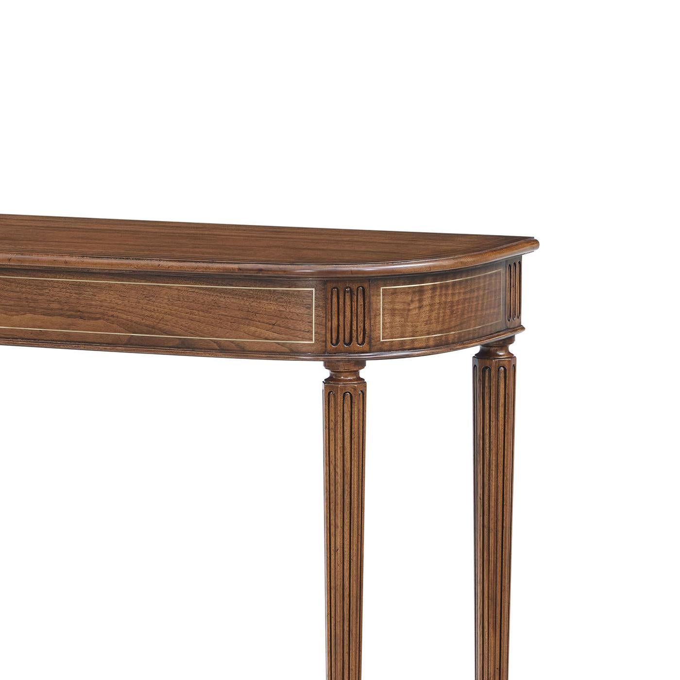 Aporta una presencia grácil y una geometría refinada a los interiores formales. Diseñada según la tradición de la artesanía inglesa de principios del siglo XIX, esta elegante pieza presenta un cálido acabado en nogal que acentúa la belleza de su