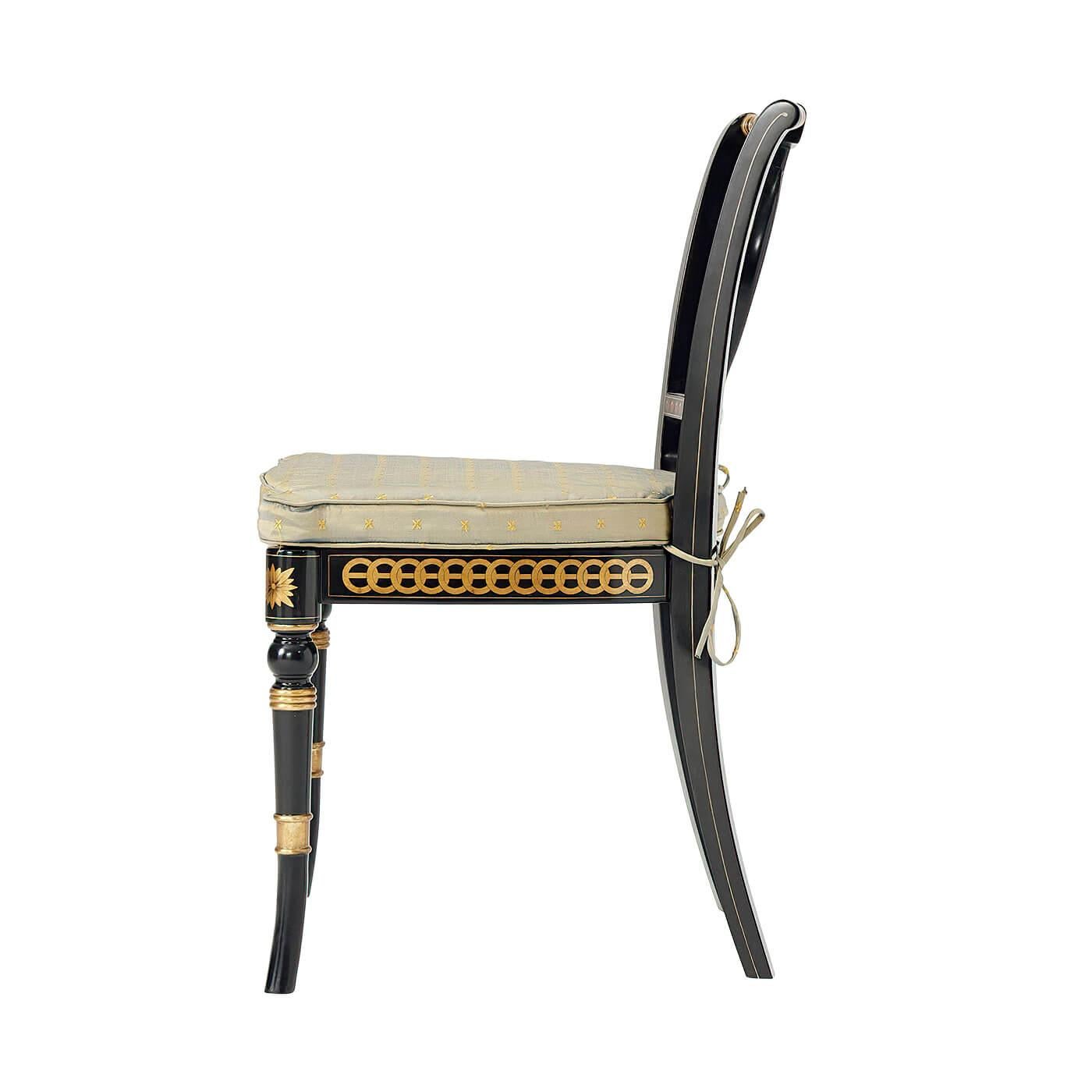 Regency style ebonized and parcel-gilt side chair, the turned and carved over scrolled top rail centered by a gilt and painted pierced splat in the form of two interlacing ovals within another oval, above a caned seat with a silk cushion embroidered