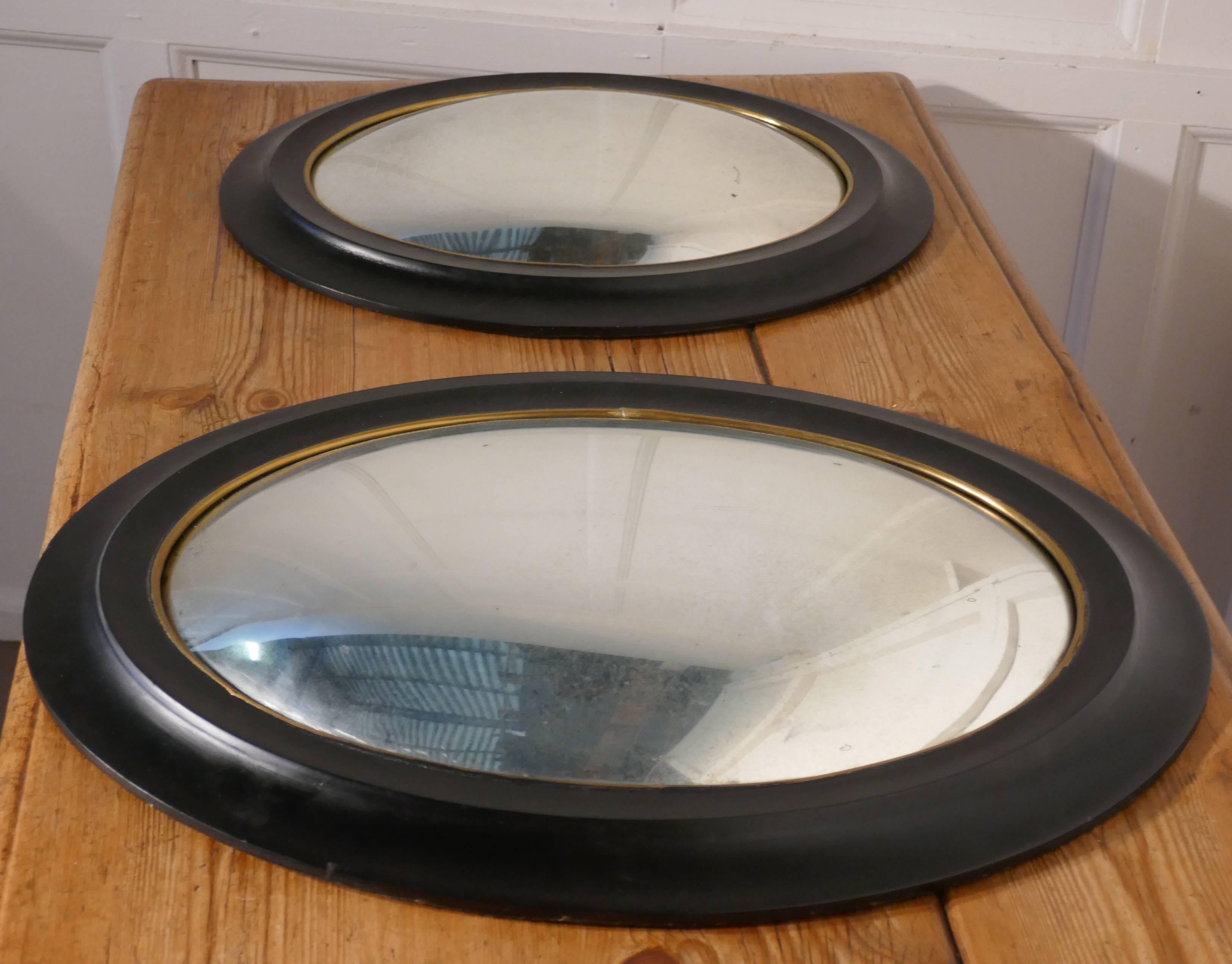 Regency style ebonised convex oval wall mirror.

A delightful piece, the looking glass is a deep oval convex shape, it has a 3” broad moulded ebonised frame
This lovely mirror is one of two, they are different in size and look wonderful when set