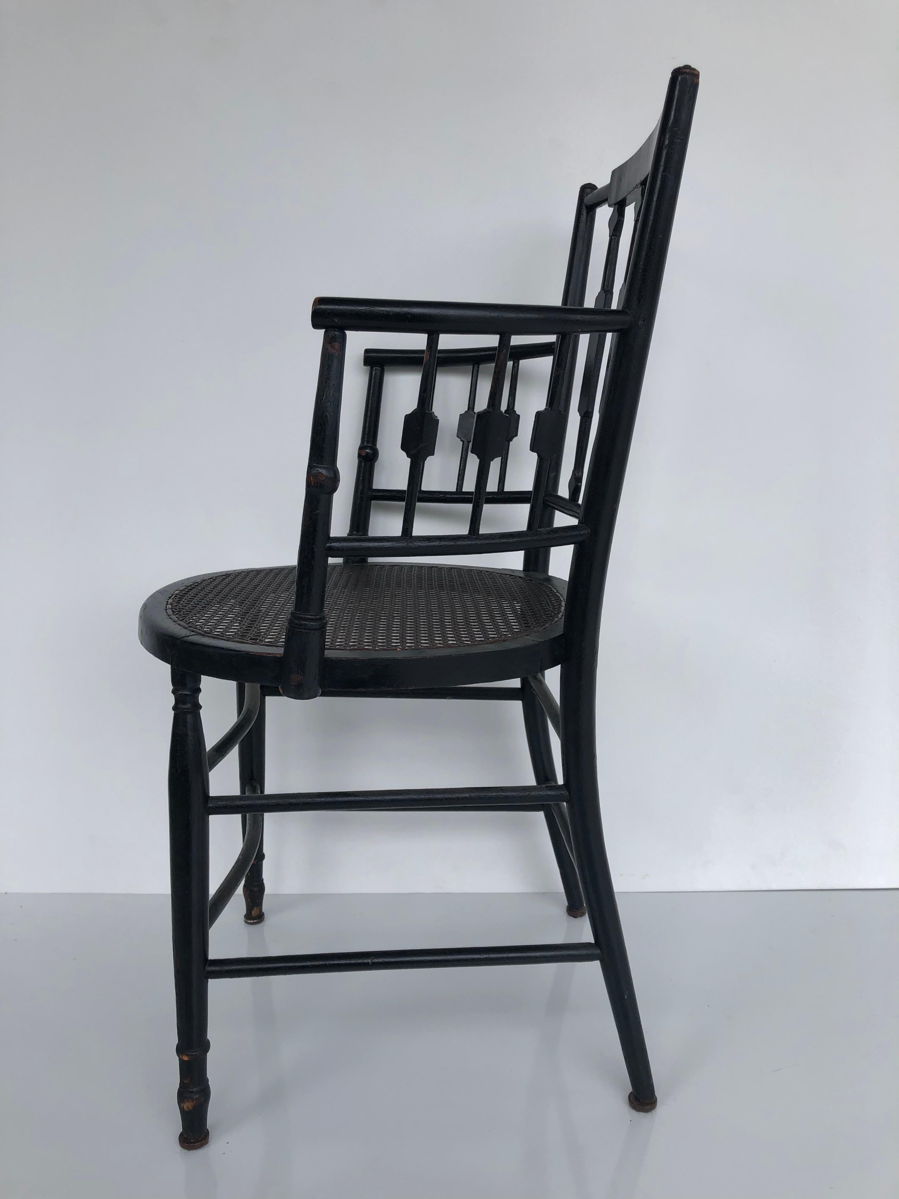Canne Paire de fauteuils à dossier fléchi et à assise cannée de style Regency, en bois d'ébène