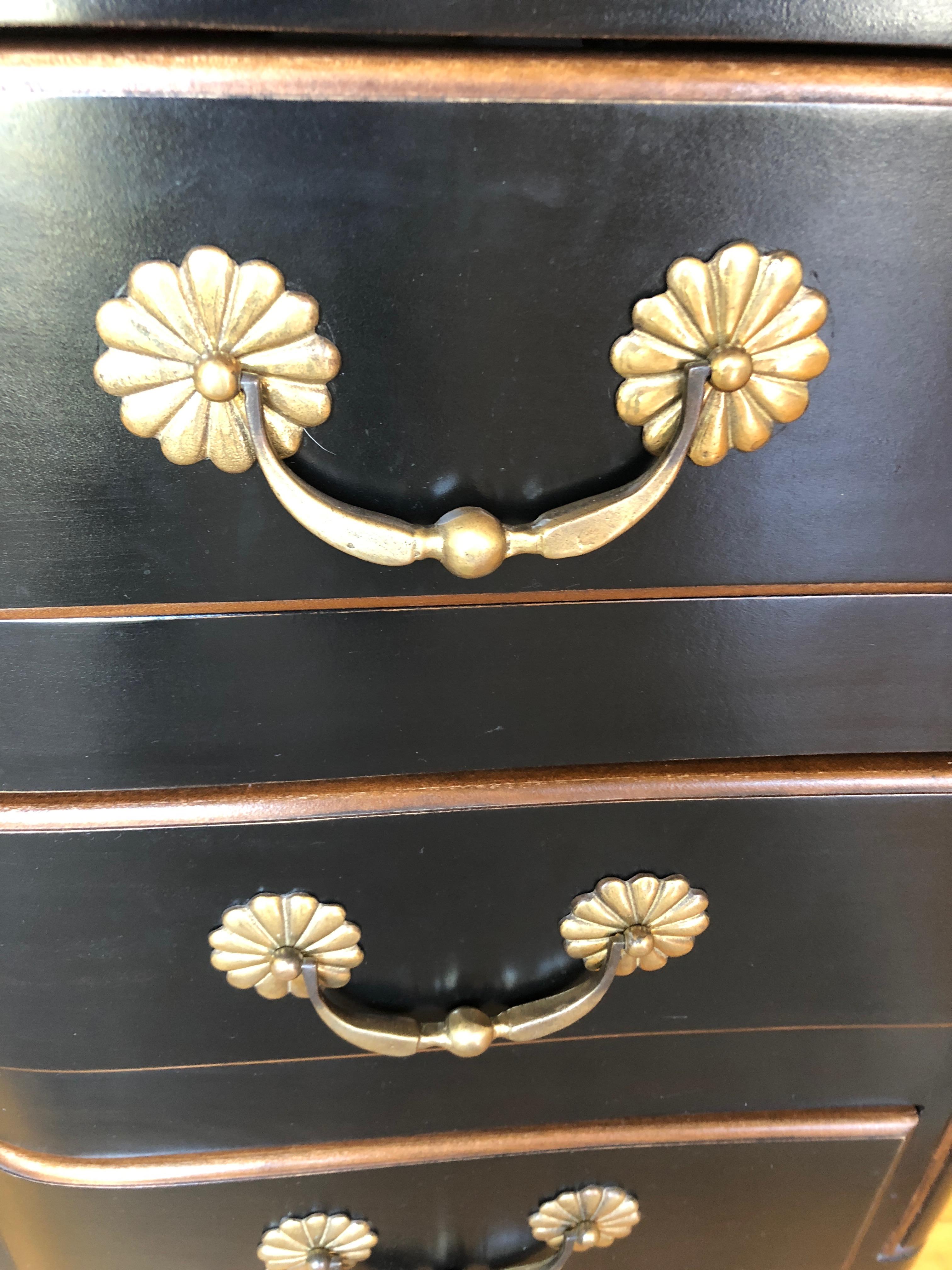 Impressive and elegant black ebonized serpentine chest of drawers having 3 large drawers and stunning gold decorative hardware. Detailed edges are a rich mahogany that offsets the black beautifully.