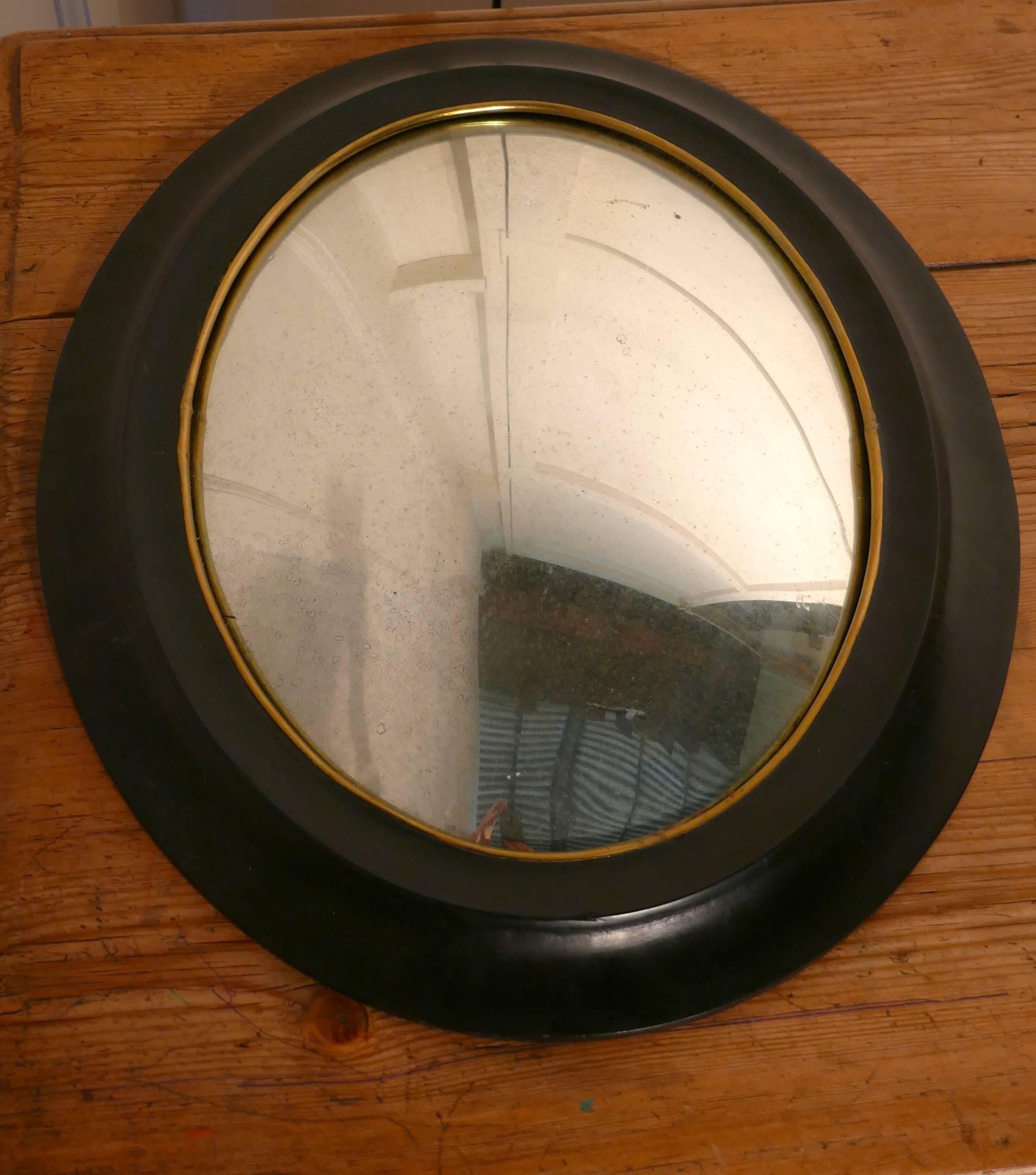 Regency style ebonized convex oval wall mirror 

A delightful piece, the looking glass is a deep oval convex shape, it has a 3” broad molded ebonized frame.
This lovely mirror is one of two, they are different in size and look wonderful when set