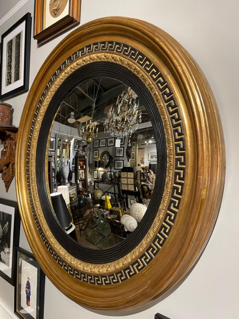 Fantastic looking large scale gilt wood round convex bullseye mirror with ebonized interior molding and black neoclassical Greek Key decorative motif. This is a truly handsome custom made mirror in the English Regency style. With the scale that will