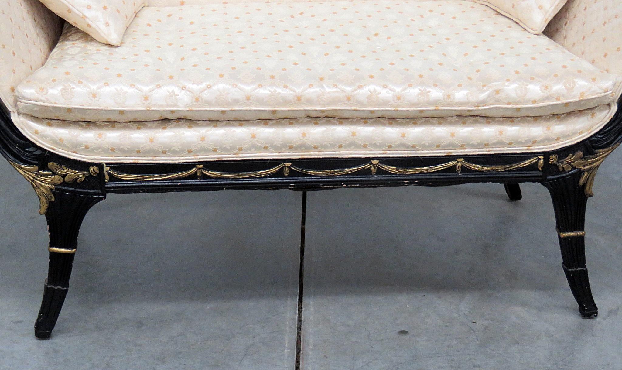 Regency style ebonized settee with textured upholstery, distressed gilt accents, and 2 matching accent pillows.