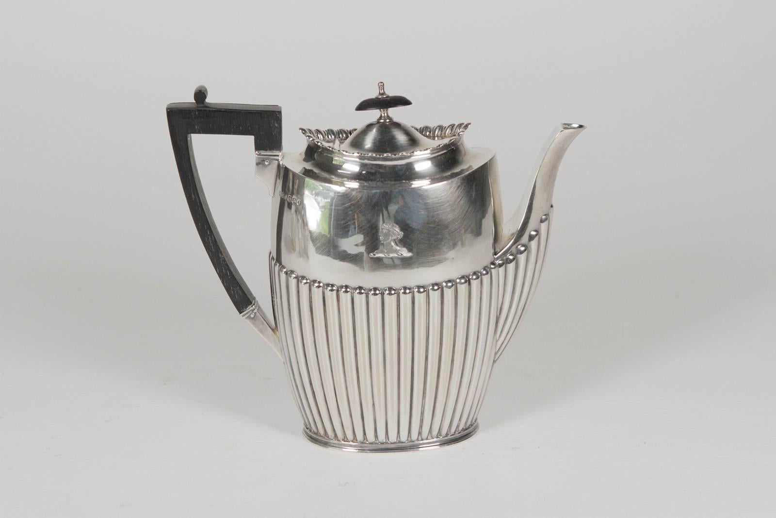 Regency style English sterling four-piece tea And coffee service, James Dixon & Sons, London year mark 1896, Each piece with ribbed design and engraved moor with ebonized handles The set is a smaller size measuring tea 9.5 H x 3.5 D x 8.5 H Coffee