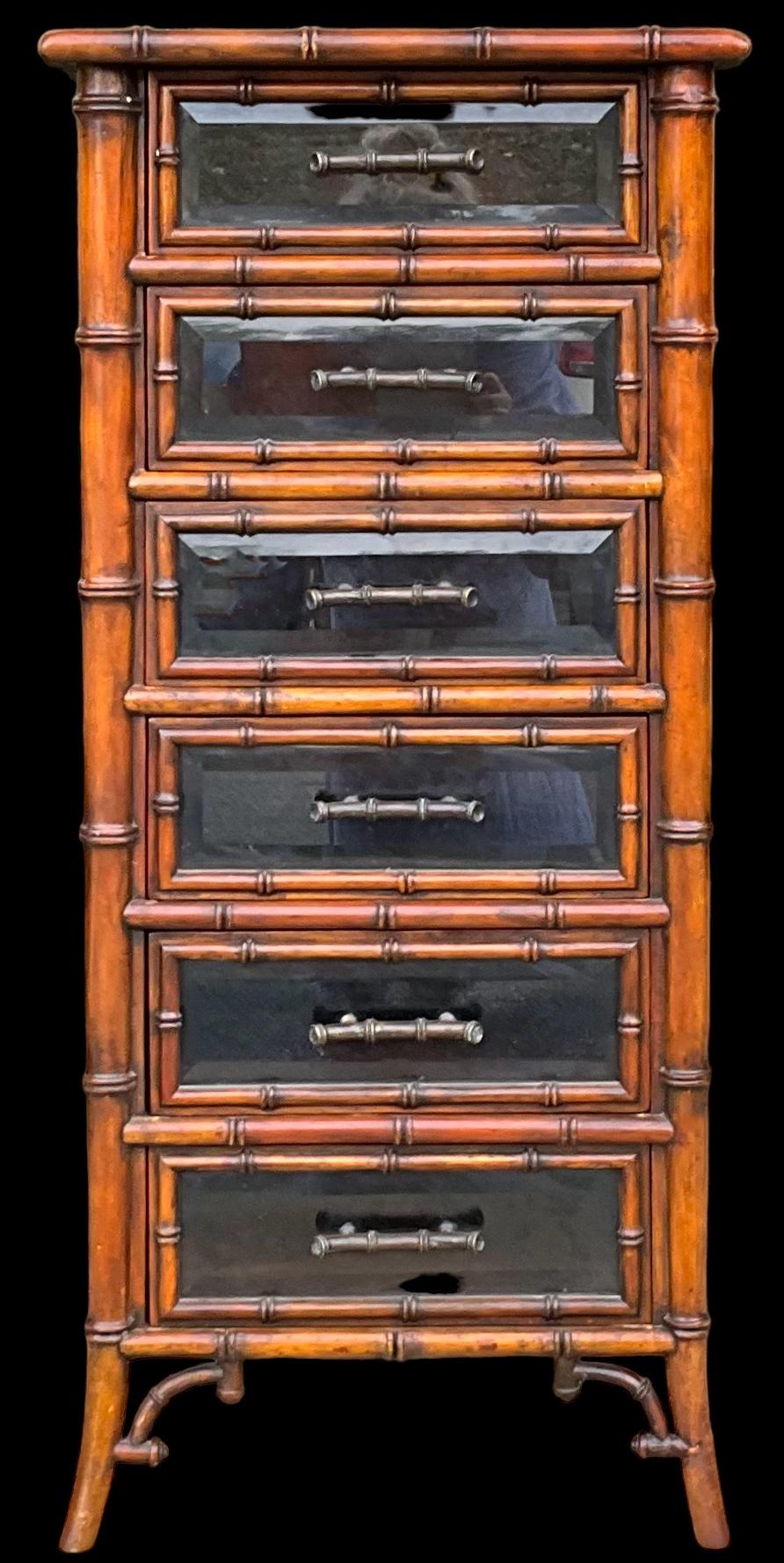This is a regency style faux bamboo lingerie / jewelry chest comprised of tooled leather, fruitwood, and bronze. It is attributed to Maitland-Smith. Each drawer front is beveled glass. The piece has lite wear but is in very good condition. 

We