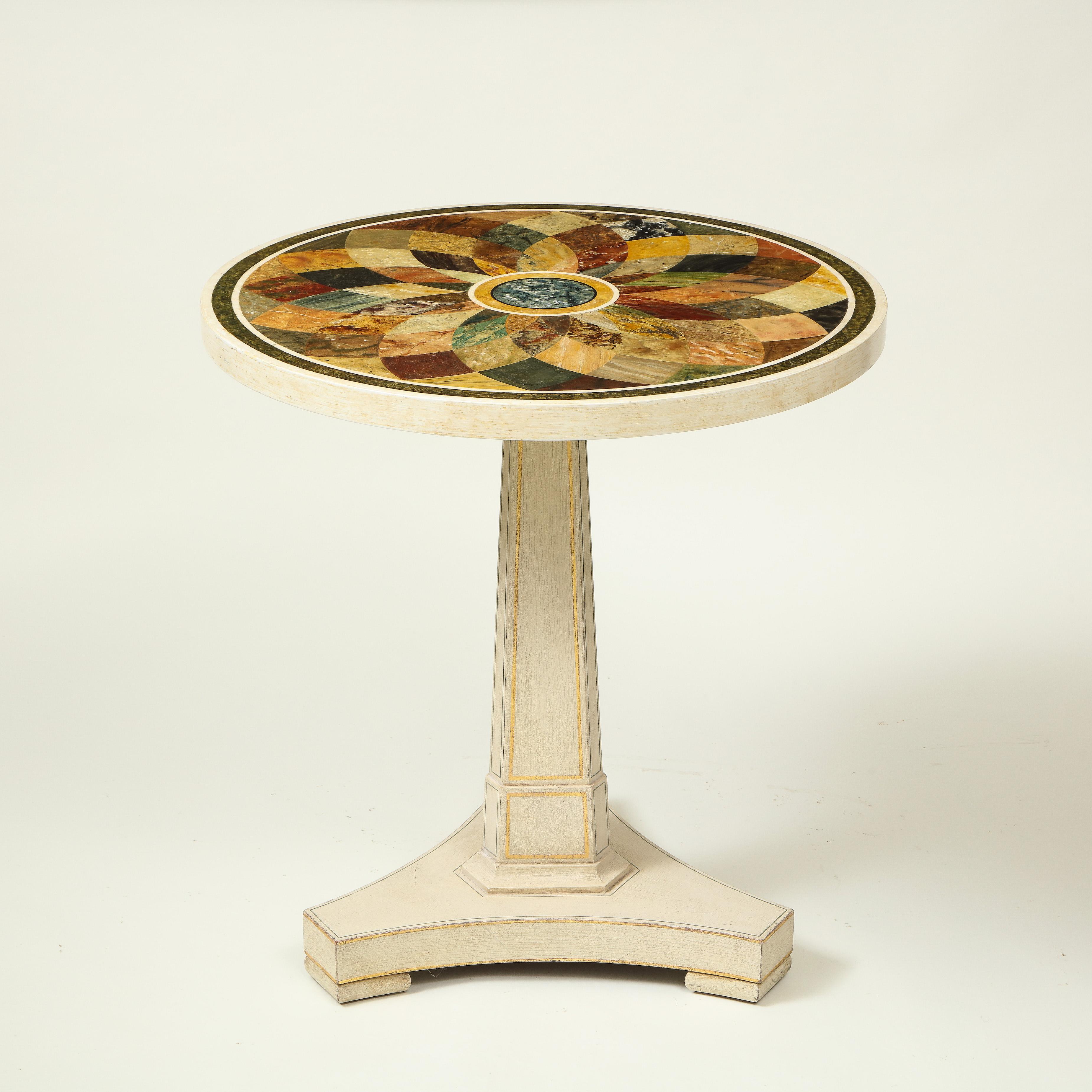 The circular top painted with radiating faux specimen marbles, raised on an ivory-painted spreading square columnar support on tripartite plinth base and block feet, with gilt and ebony painted stringing. Attributed to Colefax &