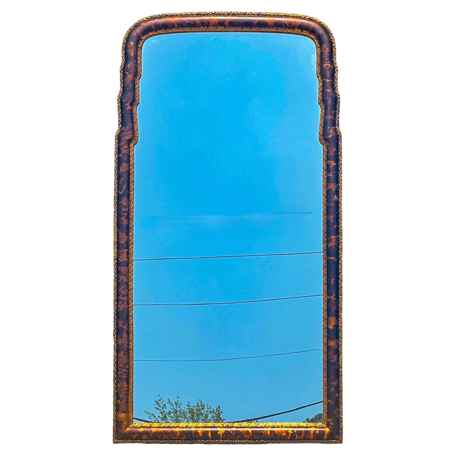 This is a regency style mirror with a faux tortoise and carved gilt finish. It is attributed to LaBarge. The mirror is both composition and wood. It is unmarked and in very good condition.