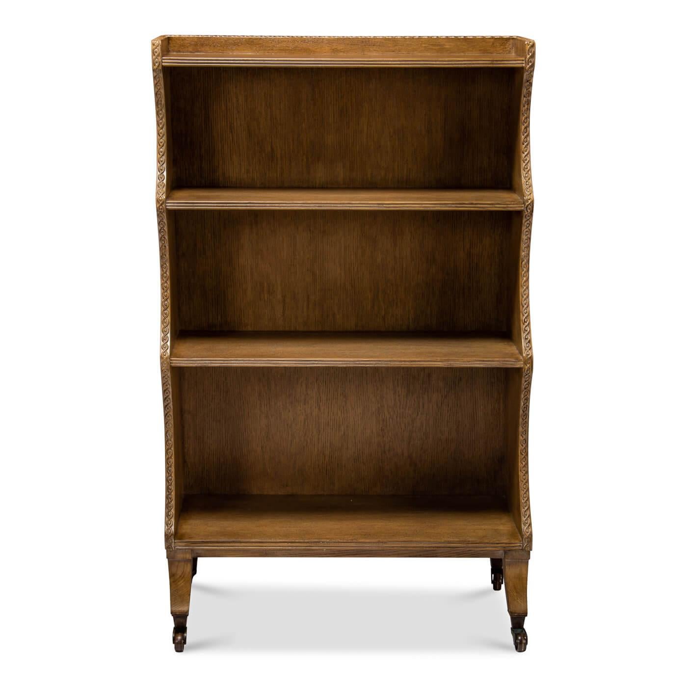 An English Regency style four-tier bookcase with a curved frame design. The oak bookcase is full of unique details including a carved guilloche detail along the top and sides, graduating shelves, raised on sabre form legs and brass castor feet. A