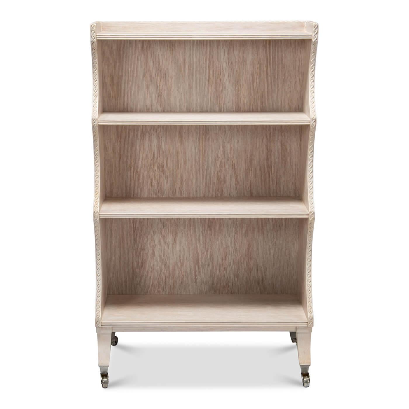 An English Regency-style four-tier bookcase with a whitewashed finish and curved frame design. The oak bookcase is full of unique details including a carved guilloche detail along the top and sides, graduating shelves, raised on sabre form legs and