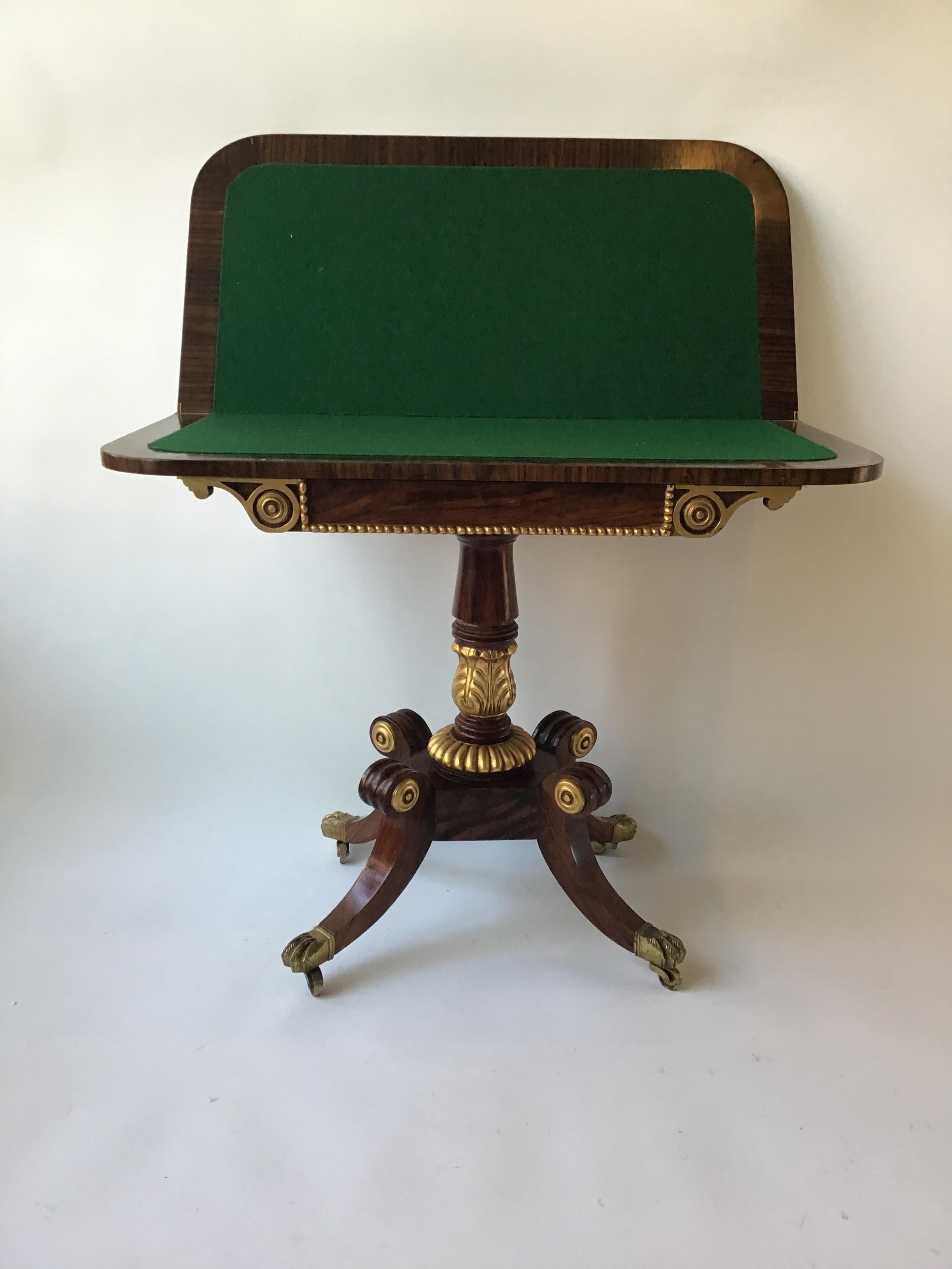 Regency style game table with gilt accents. Compartment to hold game pieces. Brass feet.