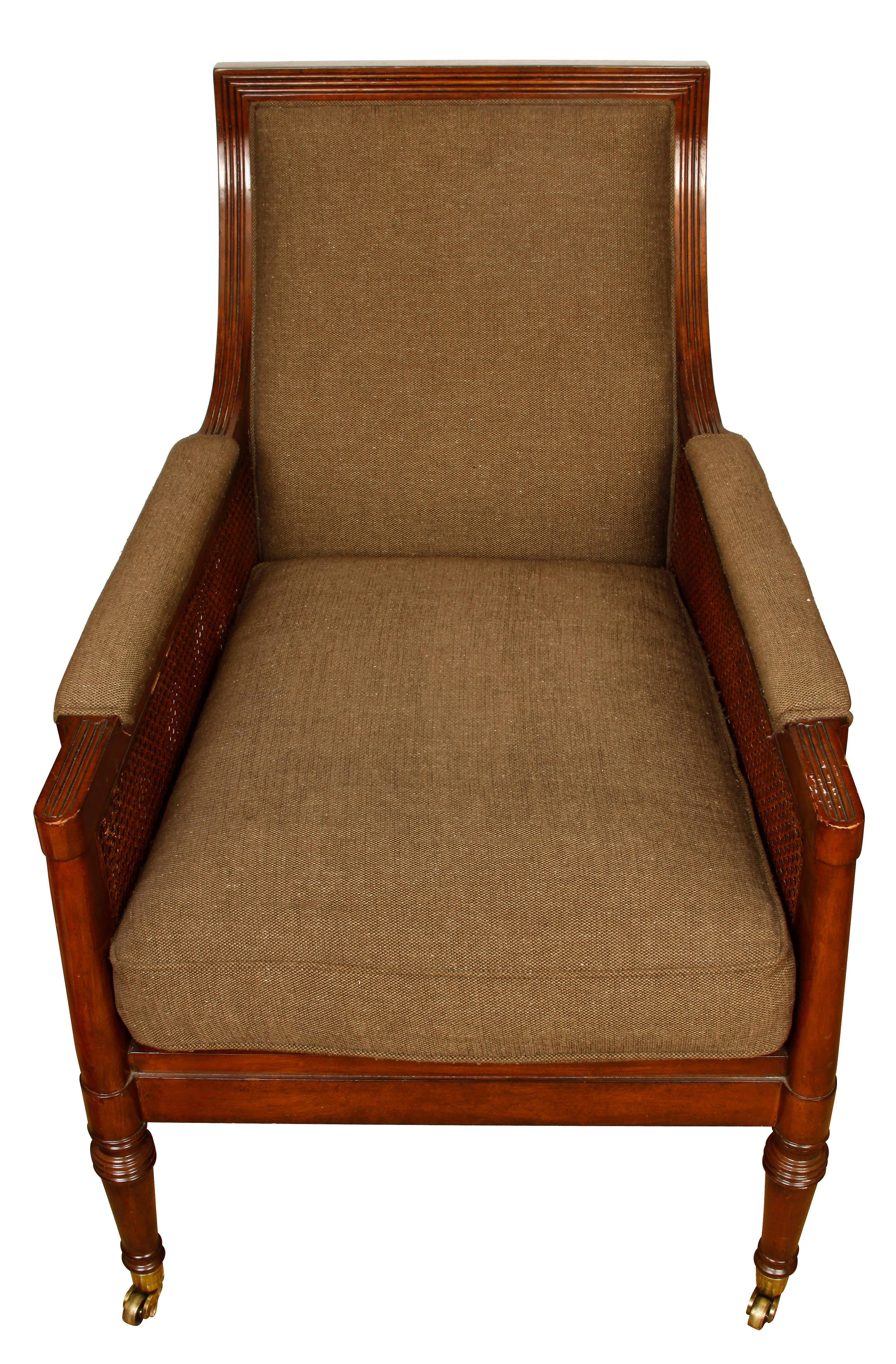 Regency style George III armchair with caned sides, upholstered seat and back with casters on front legs.