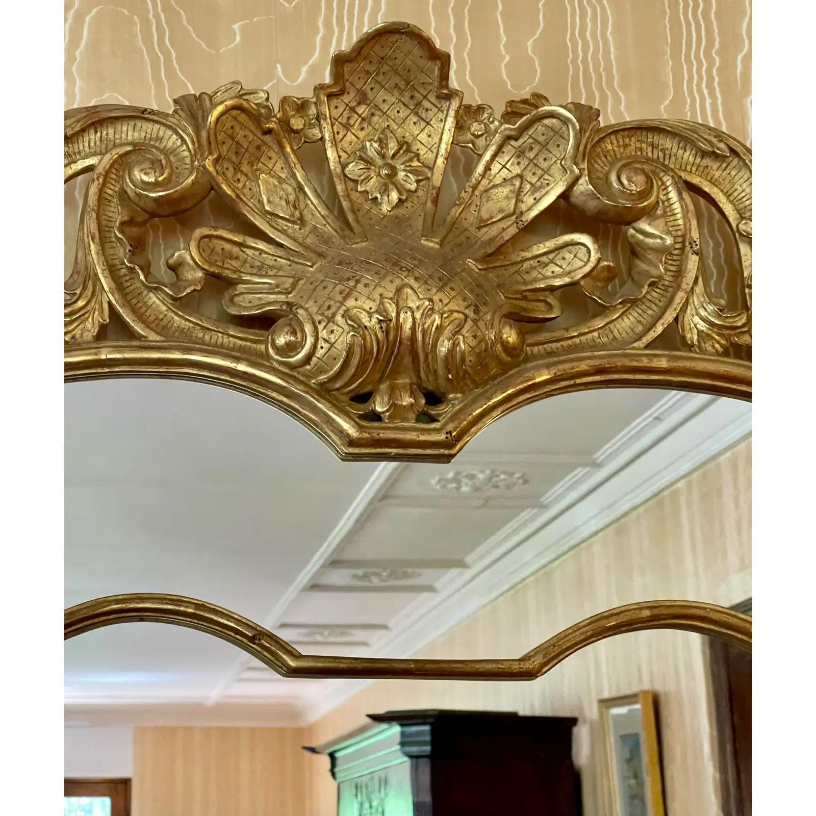 Miroir rococo en bois doré de style Régence par Villa Melrose. Doté d'une finition dorée exquise et très coûteuse avec une forme décorative élaborée en bois sculpté.

Informations complémentaires : 
Matériaux : Bois doré, Miroir
Couleur :