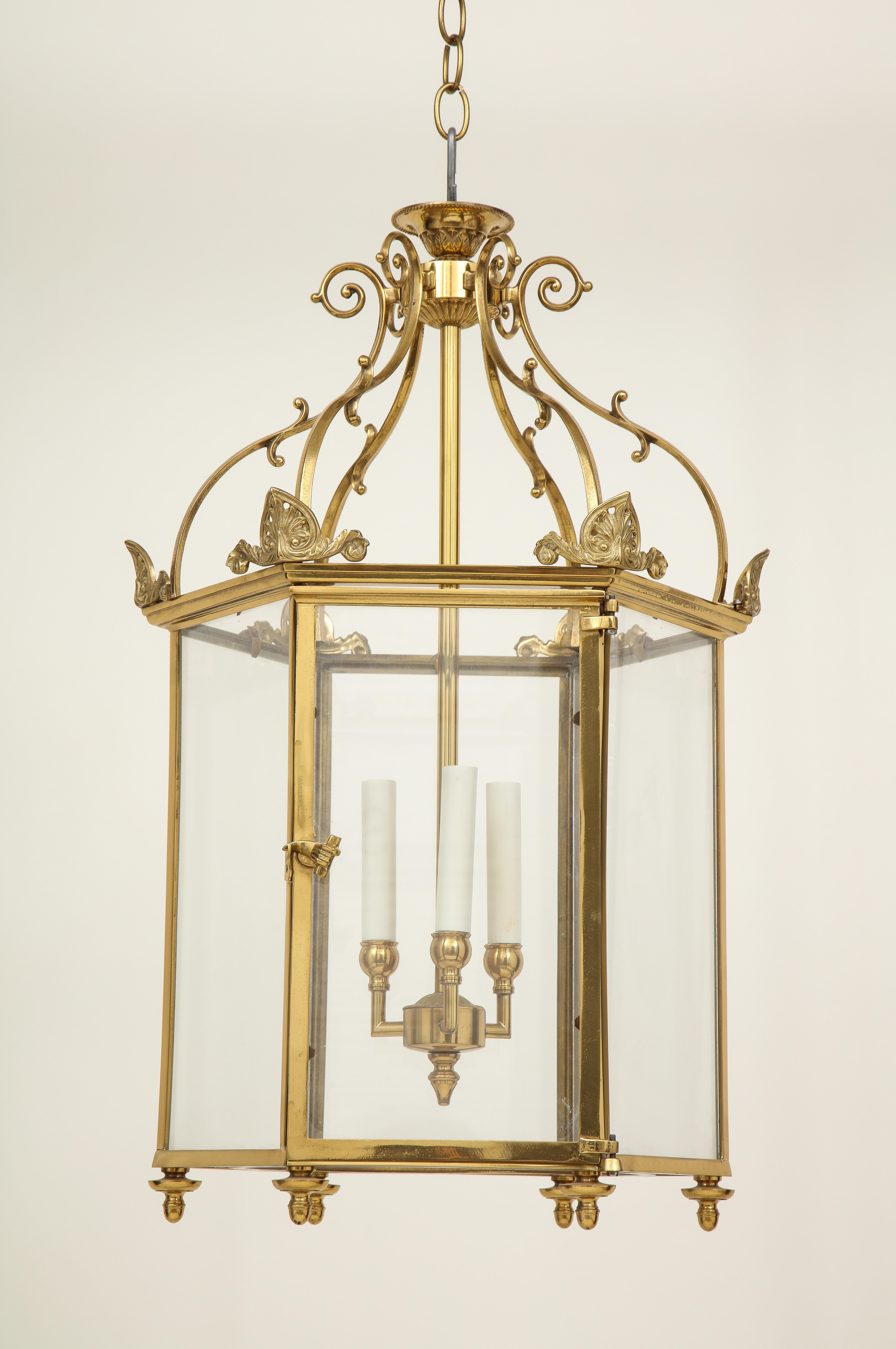 Of hexagonal form; surmounted by anthemion finials and S-scroll brackets. With four electrified candle sleeves.