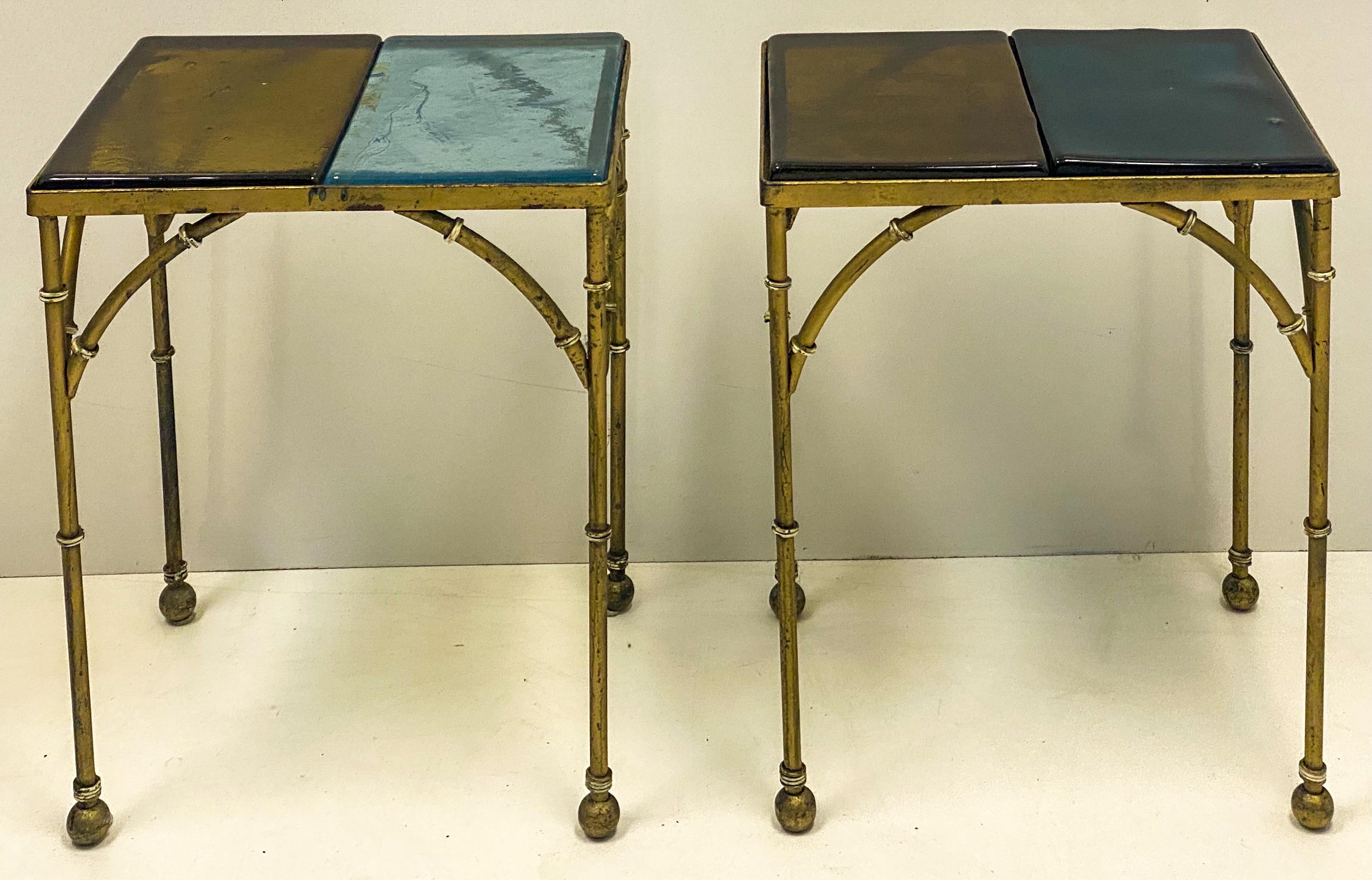 This is a pair of unusual heavy cast brass faux bamboo side tables with hand blown blue and amber glass inserts in two different shades. They are in very good condition and could work inside and out.