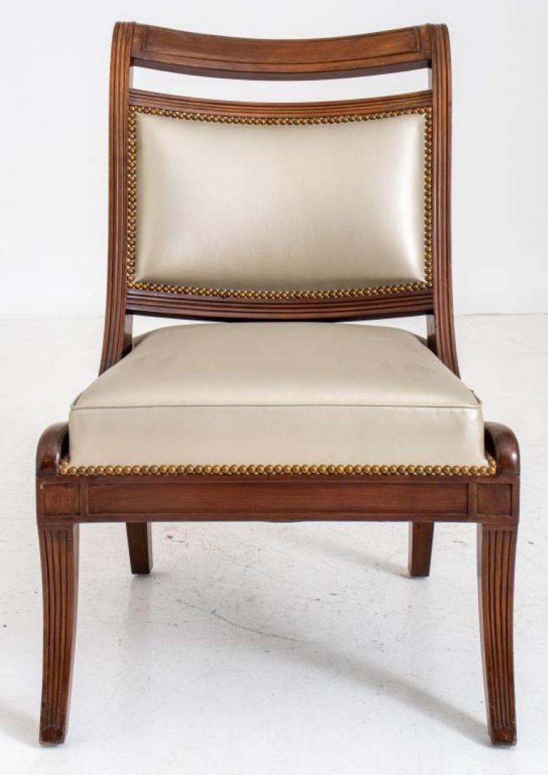 Regency style large mahogany chair without arms in the manner of Thomas Hope (English, 1769 - 1831), the rectangular brass-nailed grey-leather upholstered back and seat within reeded frame, the downswept arms ending in abstract dolphin terminals