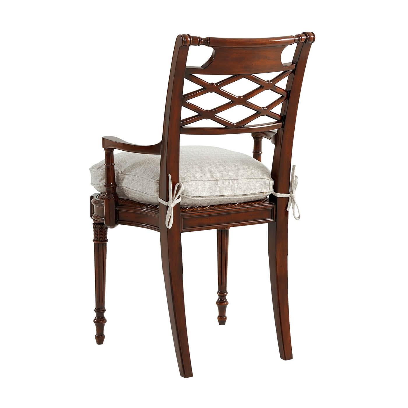 Regency style lattice back hand carved armchair, the bar top rail inset with a 'bronzed' repoussé plaque above a lattice pierced back, on a caned seat with a tie-on cushion, flanked by recessed arms, on turned and fluted legs.
Dimensions: 23