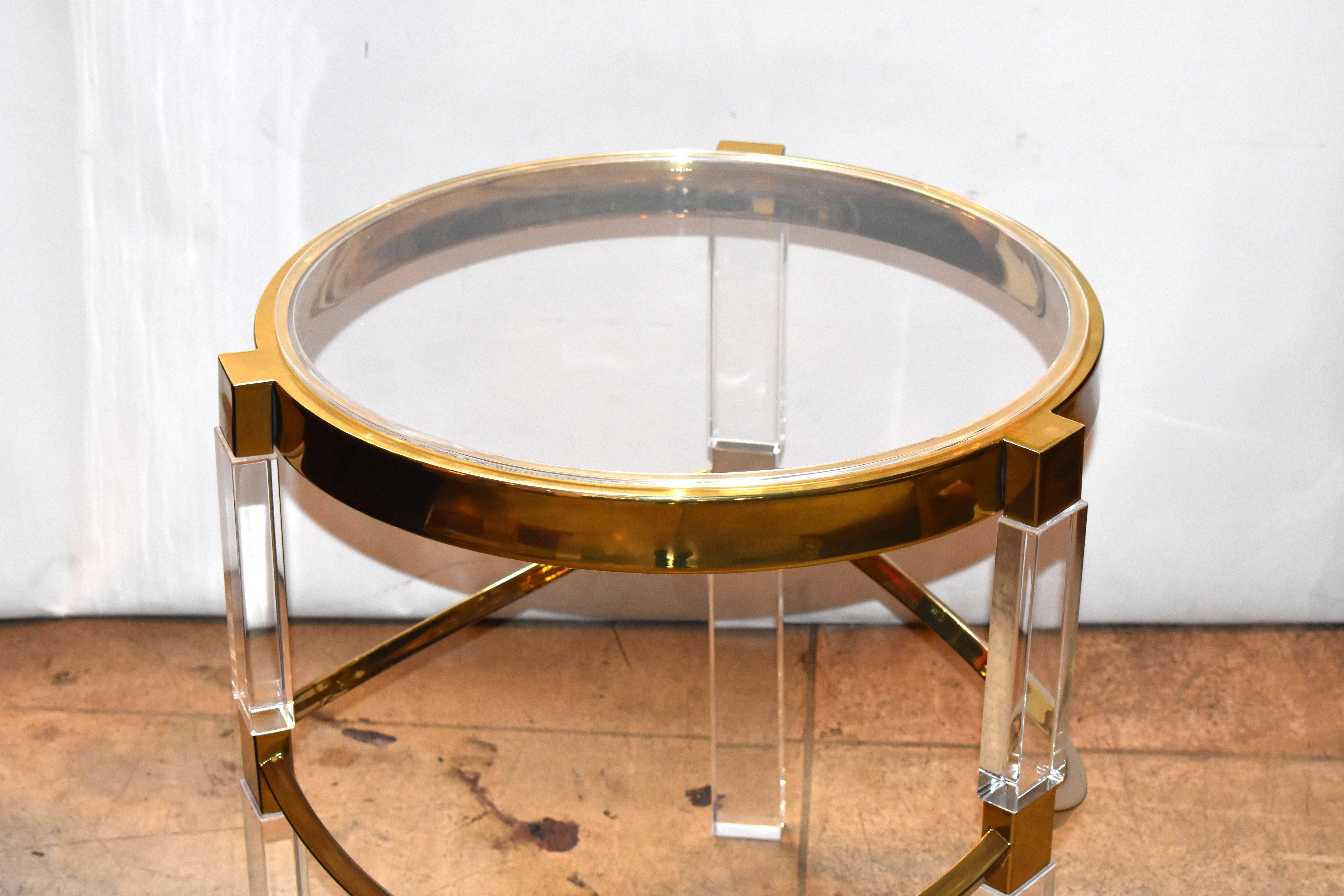 Pair of Lucite and brass side tables in the Regency style designed by Charles Hollis Jones in the 1960s.
The tables have a beautiful ornate brass base with a thick banded top, the Lucite legs are very substantial and command attention, they can be