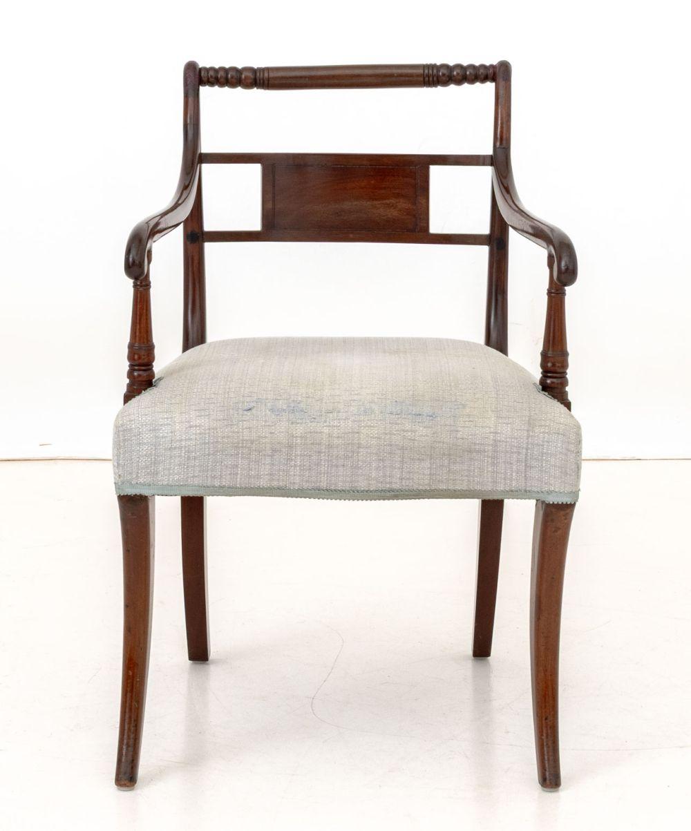 Sillón de caoba estilo Regencia, barandilla superior de madera torneada, tapicería gris. 
Alto 32,5