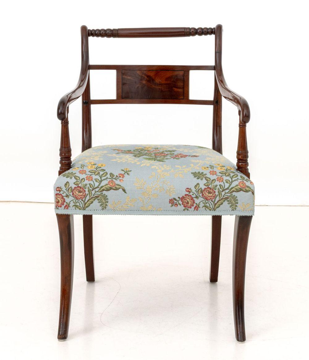 Sillón de caoba estilo Regencia, barandilla superior de madera torneada, tapicería floral azul cielo. 
Alto 32,5