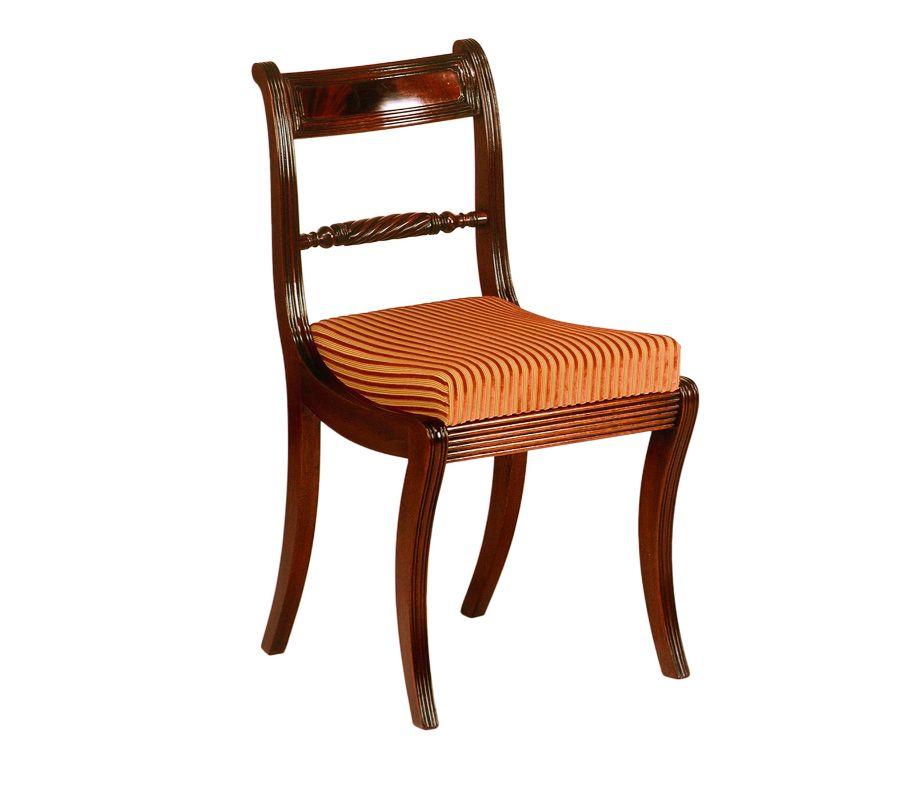 Captivating channels and gentle curves define the plush aesthetic of this precious mahogany chair. A faithful reproduction of a Regency original dating back to 1811-1830, a careful hand-carving process is responsible for the refined twisted element