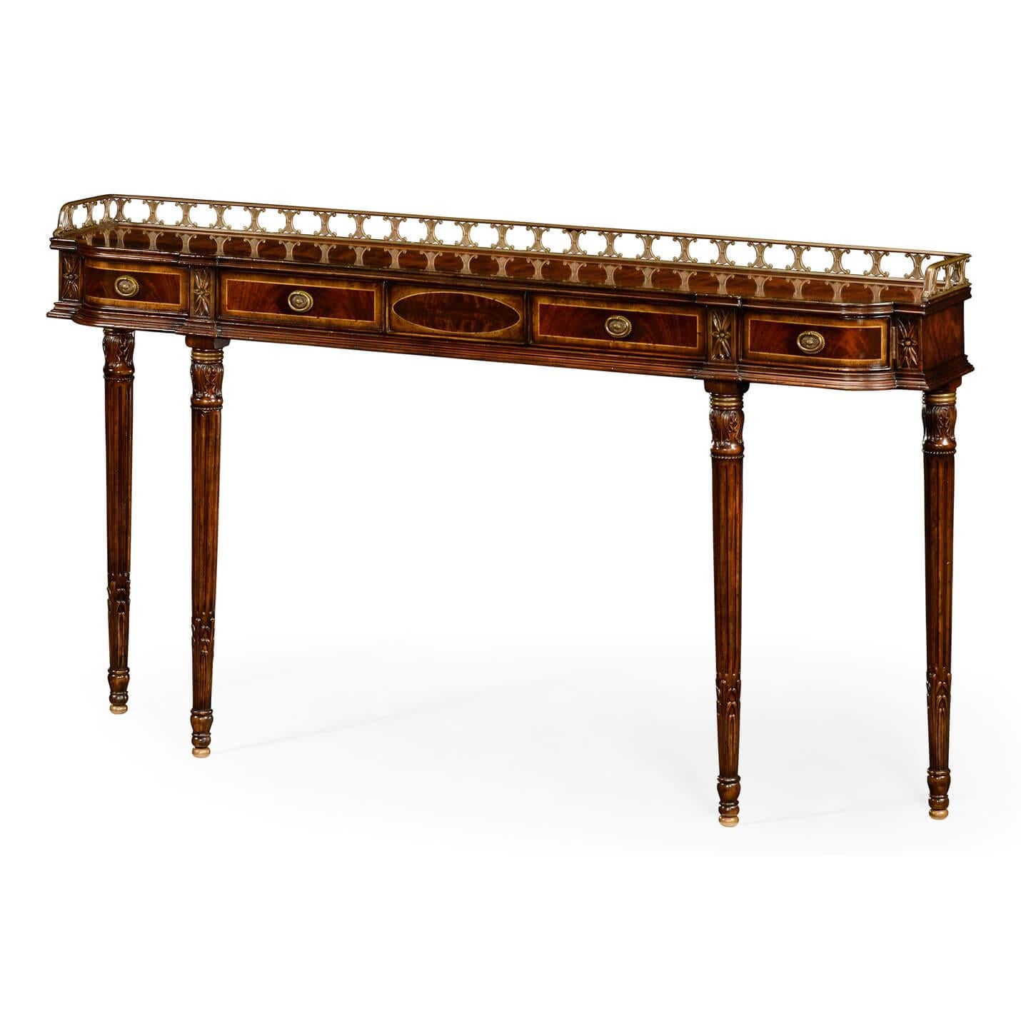An English Regency style mahogany console table with a tall pierced bronze gallery, figured mahogany veneers with cross-banded drawers, 'D' form frieze with oak secondary wood, with two swivel end drawers, a central swivel drawer flanked by two flat