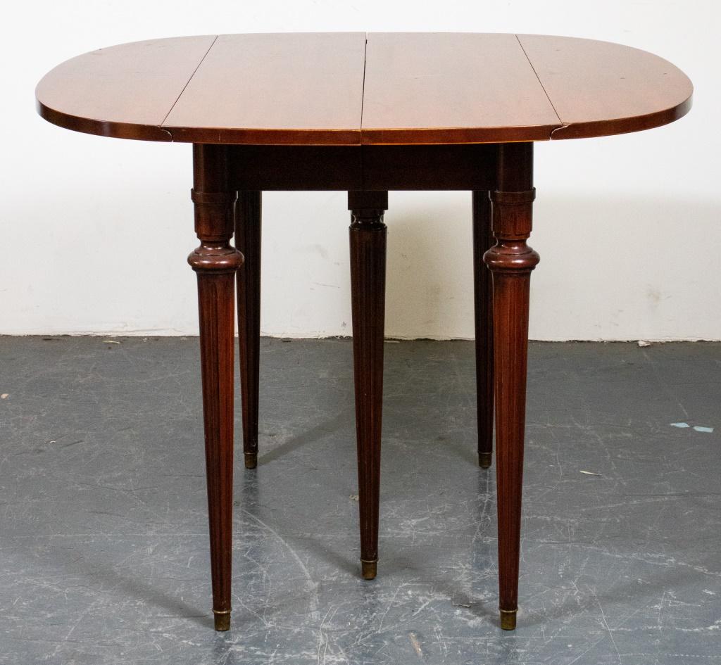Regency style mahogany drop leaf dining table, the expandable mahogany top with two drop leaves raised over turned and fluted legs terminating on brass feet, with four leaves in case stand. Wear, losses. (with drops up and without leaves) 29”H x 39”