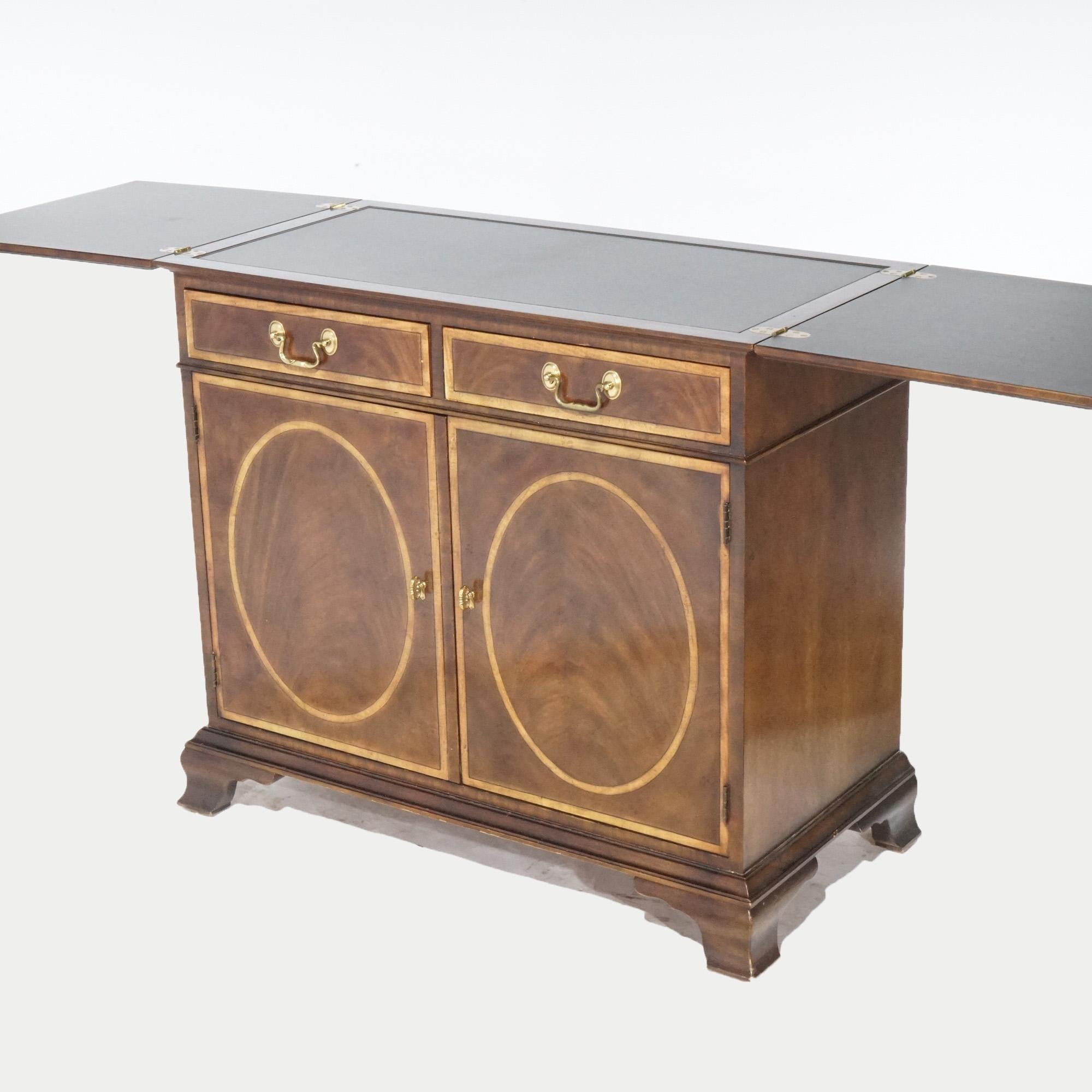 A Regency style server by Henredon offers mahogany construction with top which opens offering additional presentation space, over two banded drawers and double door cabinet having inlaid reserves and opening to shelved interior, raised on bracket