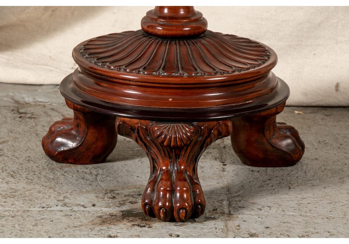 Magnifique table de couture à piédestal en acajou sculpté de style Regency, avec intérieur ajusté, plateau coulissant et pied en griffe de lion. 
Condit : Voir les photos de détail. Variously signs of age including some sporadic finish loss and 