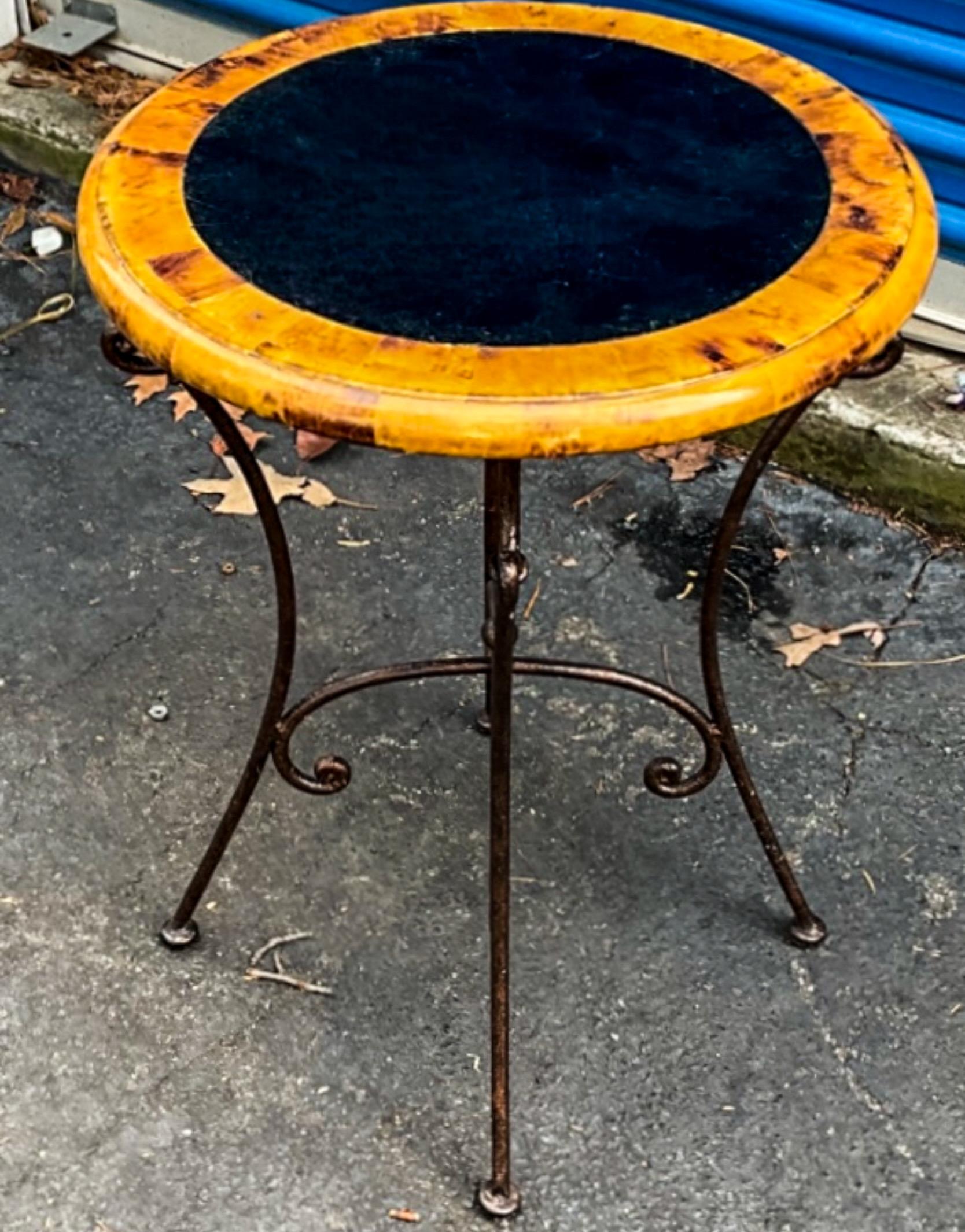 Il s'agit d'une paire de tables d'appoint en coquillage avec un aspect de fausse tortue par Maitland-Smith. Le centre noir est probablement une pierre tessellée. Les bases sont en fer à volutes. 

Ceux-ci pourraient être mis en boîte. Le programme