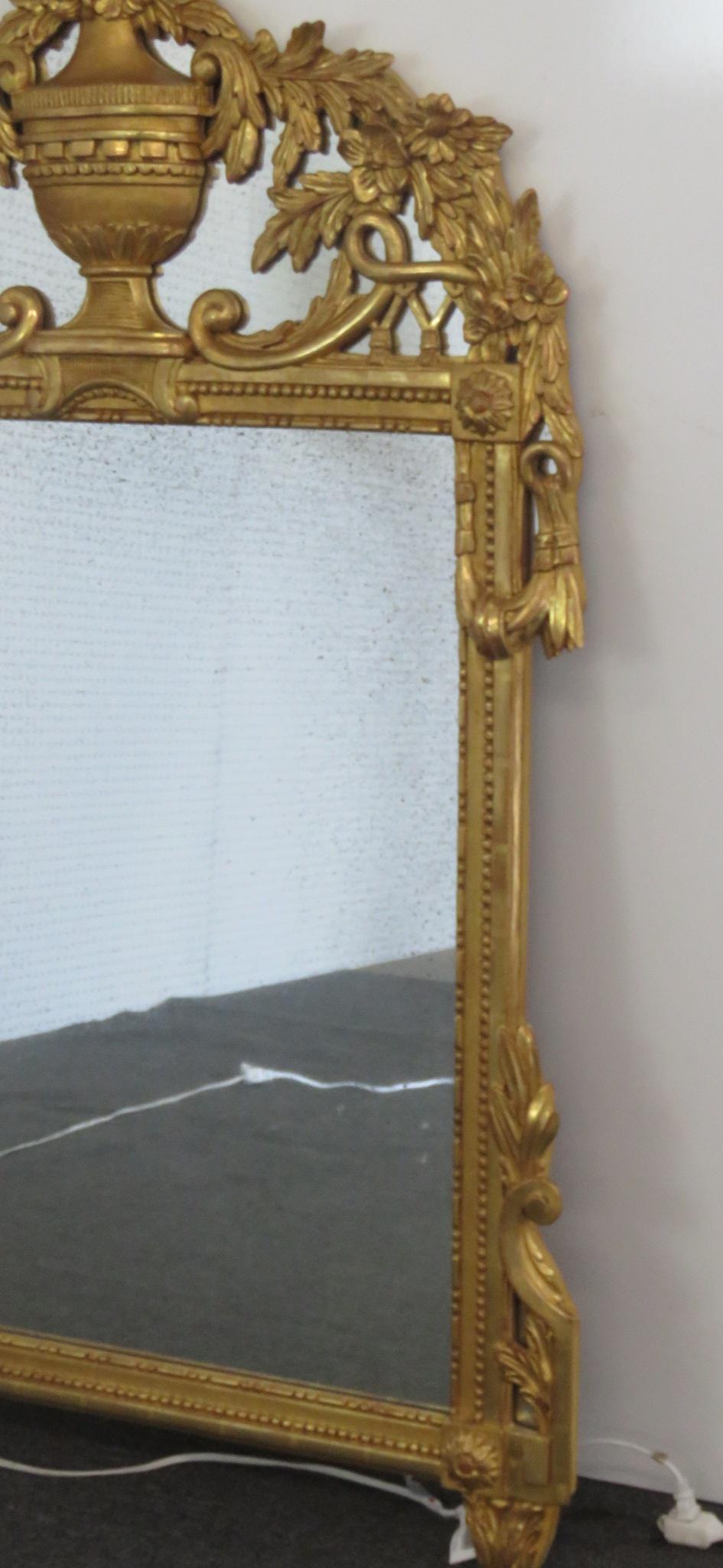 French Louis XV style mirror with a distressed giltwood frame and a distressed mirror. Made in Italy.