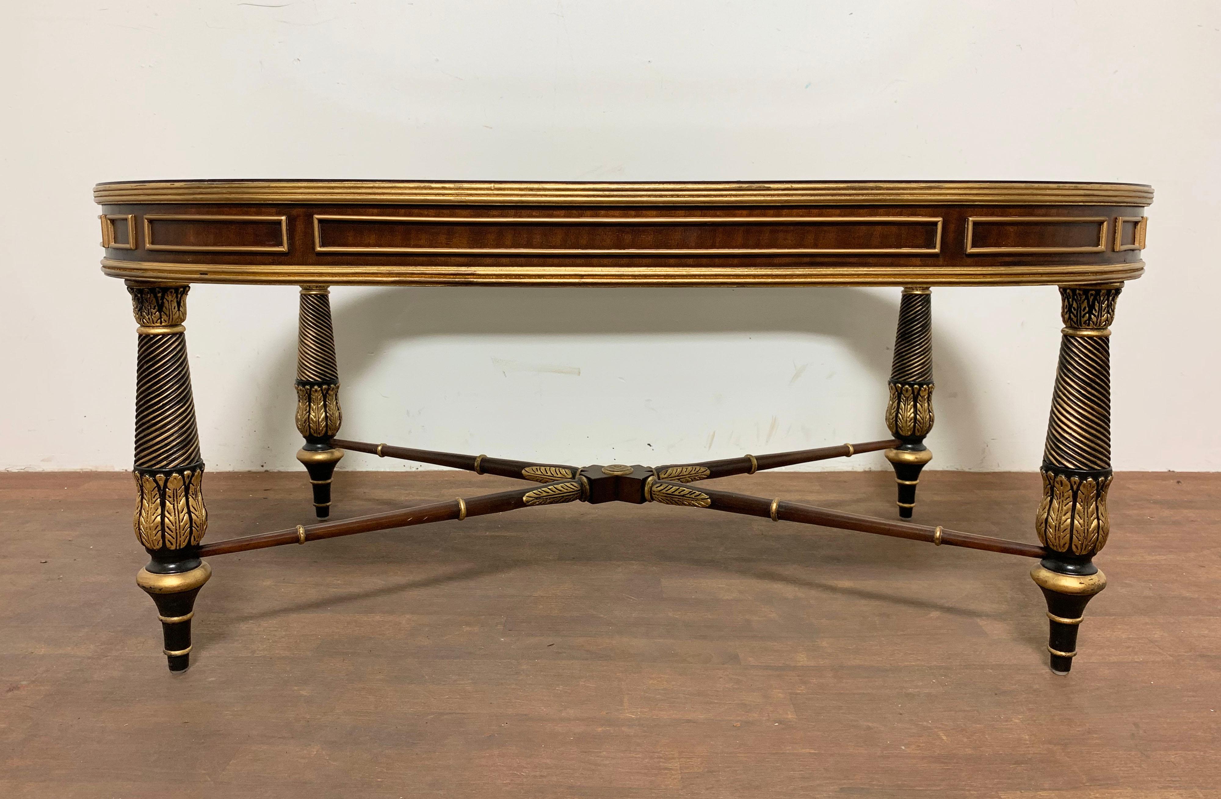 Regency style neoclassical form coffee table in mahogany with handcrafted details, gilded accents, and a beveled glass insert. By E.J. Victor Furniture of North Carolina, circa 2001.
