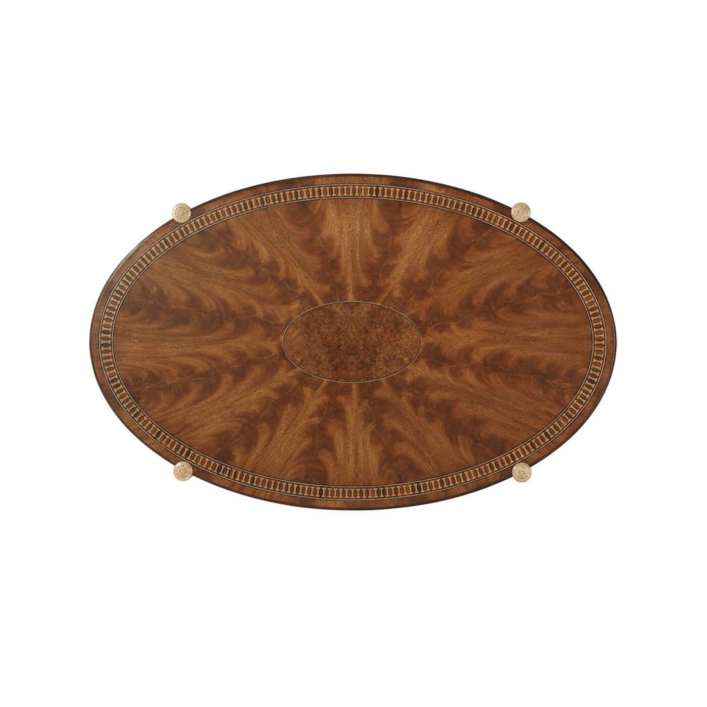 English Regency design, showcasing exquisite craftsmanship and timeless elegance. The veneered and parquetry crossbanded cocktail table features an oval caddy-molded top, centered with a striking amboyna burl veneered oval that radiates refined