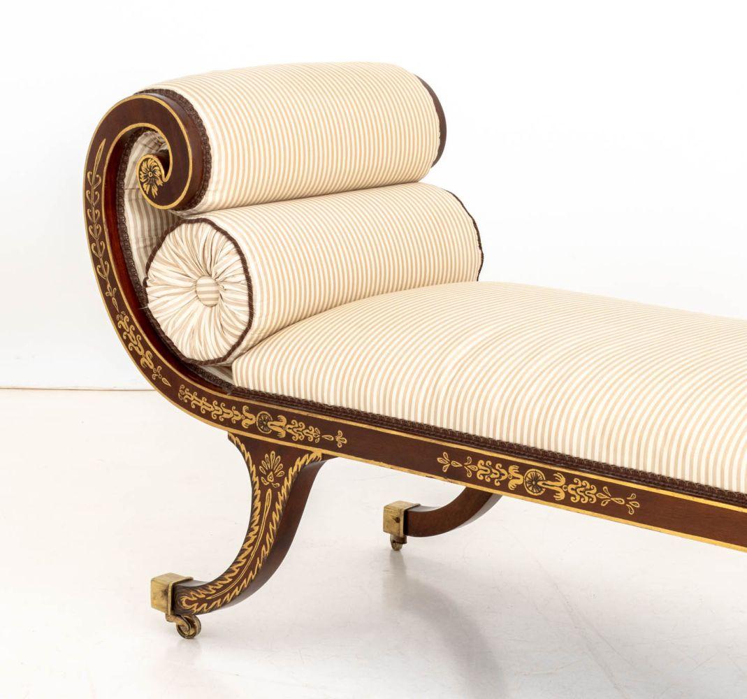 Chaiselongue aus lackiertem Mahagoni im Regency-Stil, verschnörkelte Enden mit gemaltem Blumenmuster, gestreifte Polsterung, auf Messingrollen. 
27