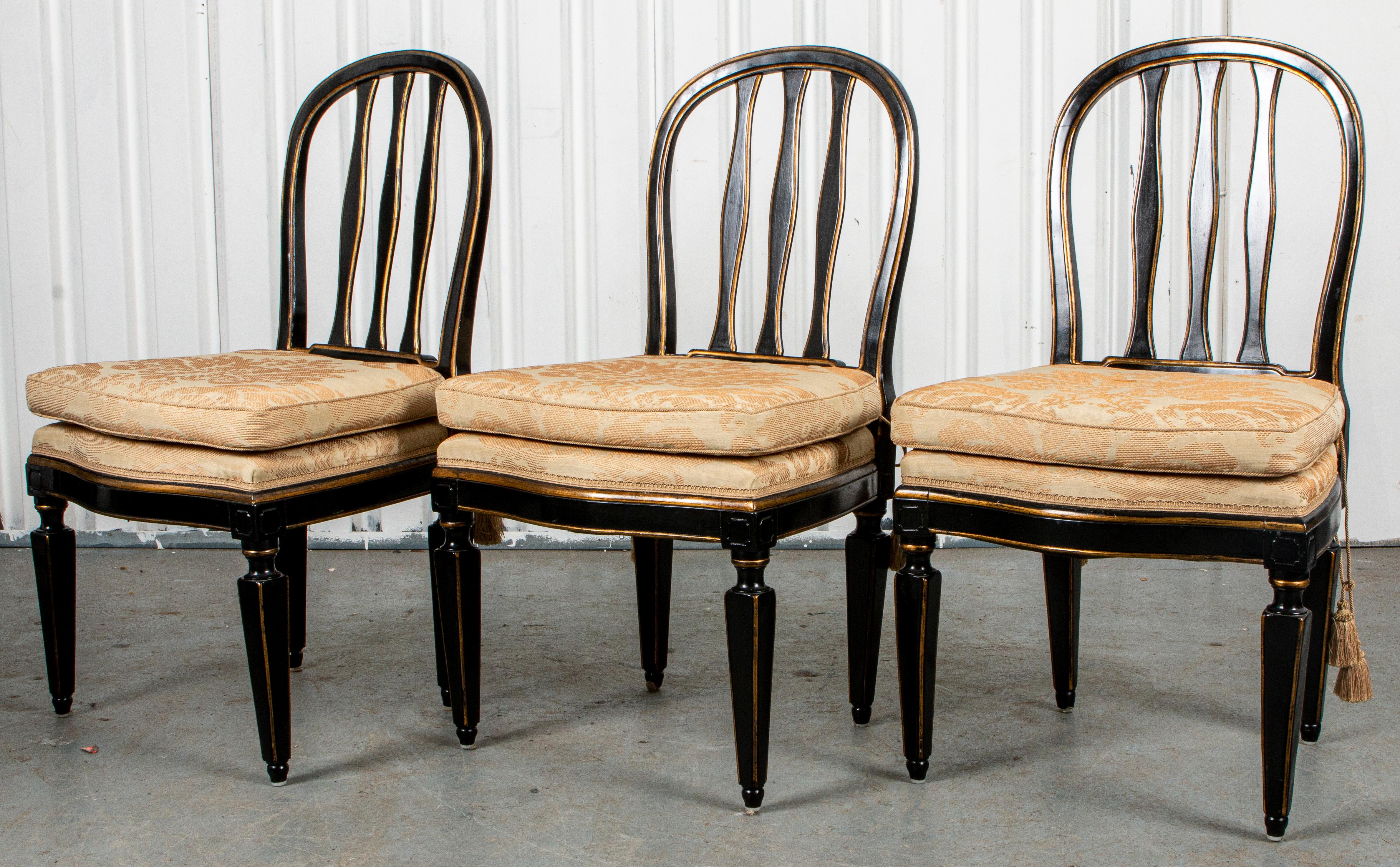 Sechs paketvergoldete, ebonisierte Beistellstühle im Regency-Stil, 20. Jahrhundert, die gewölbte Rückenlehne mit drei zentralen Latten über einem gepolsterten Sitz mit aufgeschnürten Kissen über quadratischen, spitz zulaufenden Beinen. Größe: 38