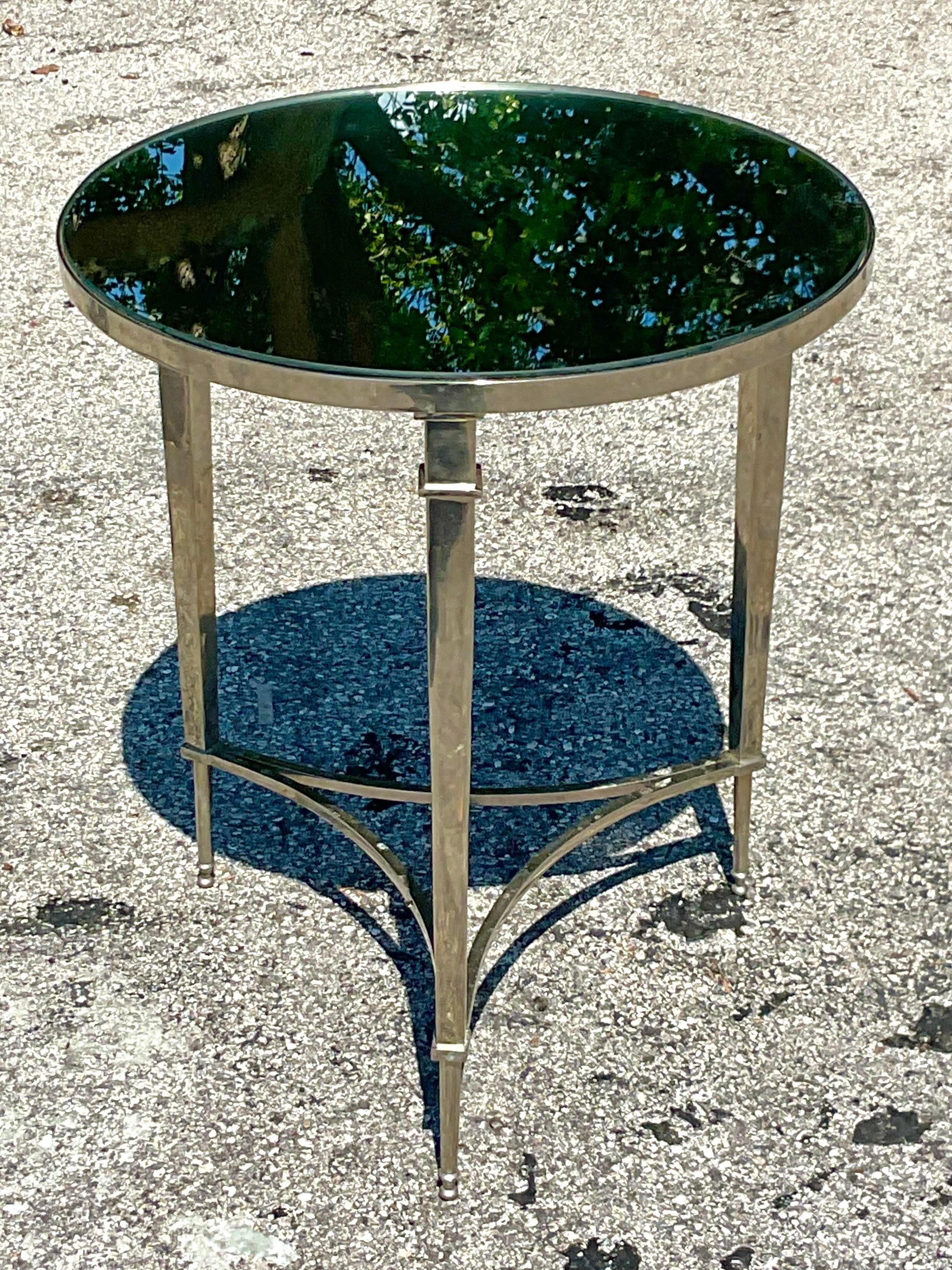 Add a touch of classic glamour to your home with the Vintage Regency Polished Nickel and Mirror Side Table. This stunning piece combines the refined elegance of Regency design with a modern twist, featuring polished nickel accents and a sleek