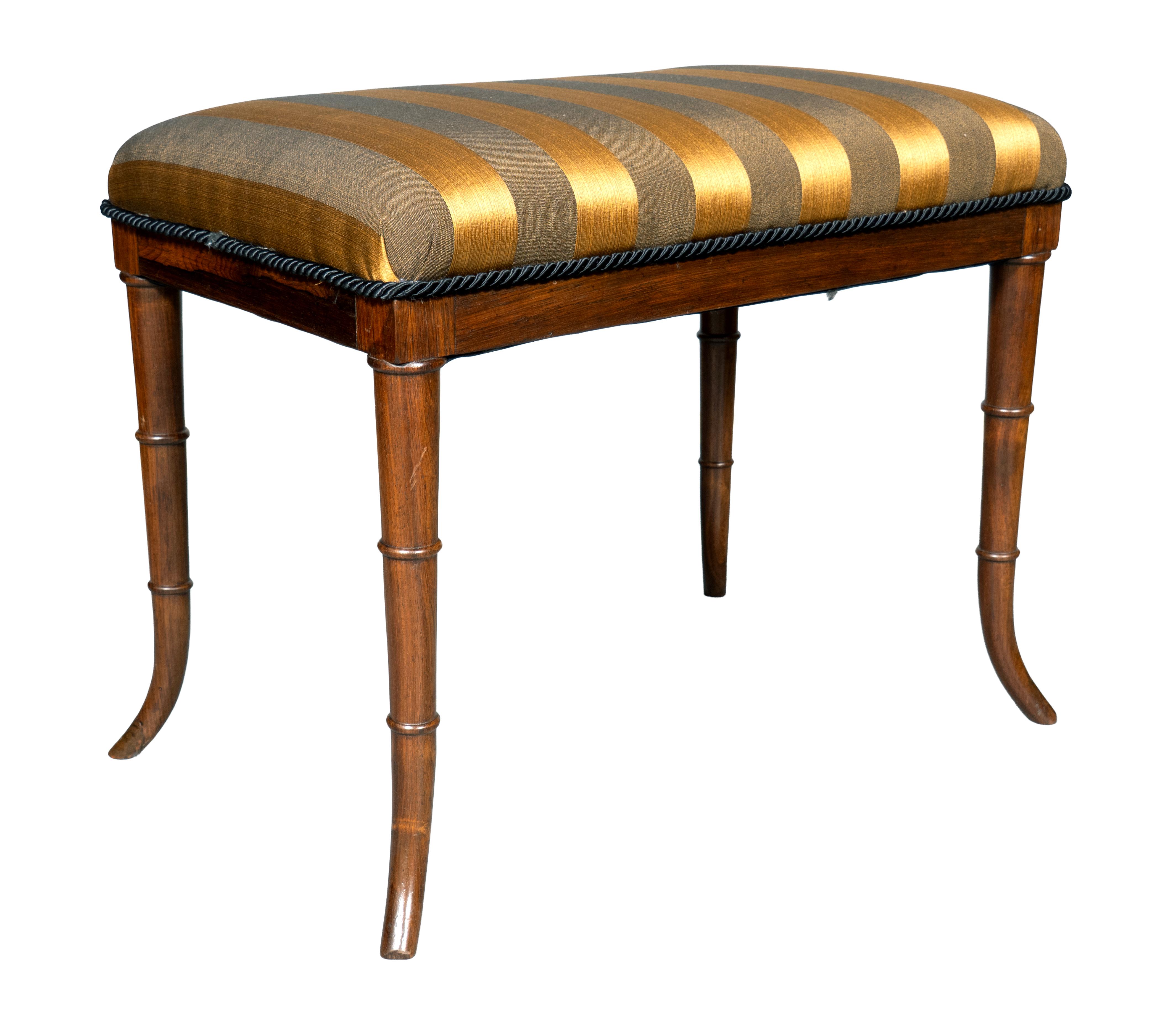 Rectangular upholstered seat with turned legs that curve out. Possibly By Wood & Hogan.