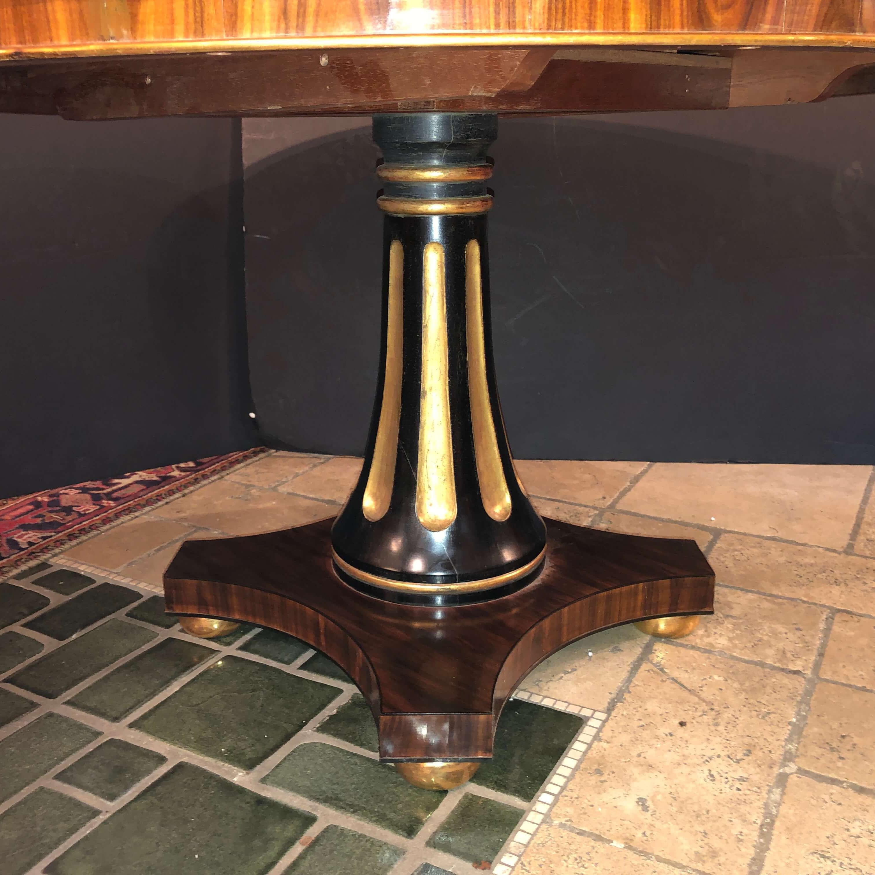 A fine English Regency style rosewood round center table with gilded trim raised on a flitted ebonized and gilt pedestal base with gilt bun feet.
Modern custom reproduction from our London Workshop.