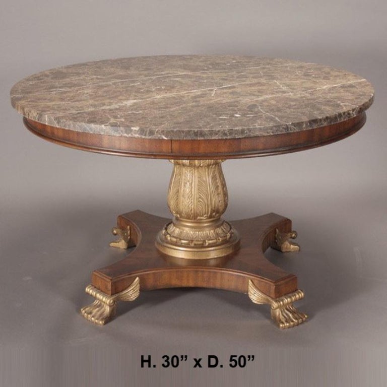 Very impressive Regency style round center table.
The beautiful round brown thick marble top over veneered frieze over carved pedestal with platform and gilt bronze lion feet with scrolls and wings,
mid-20th century.
Size: H 30